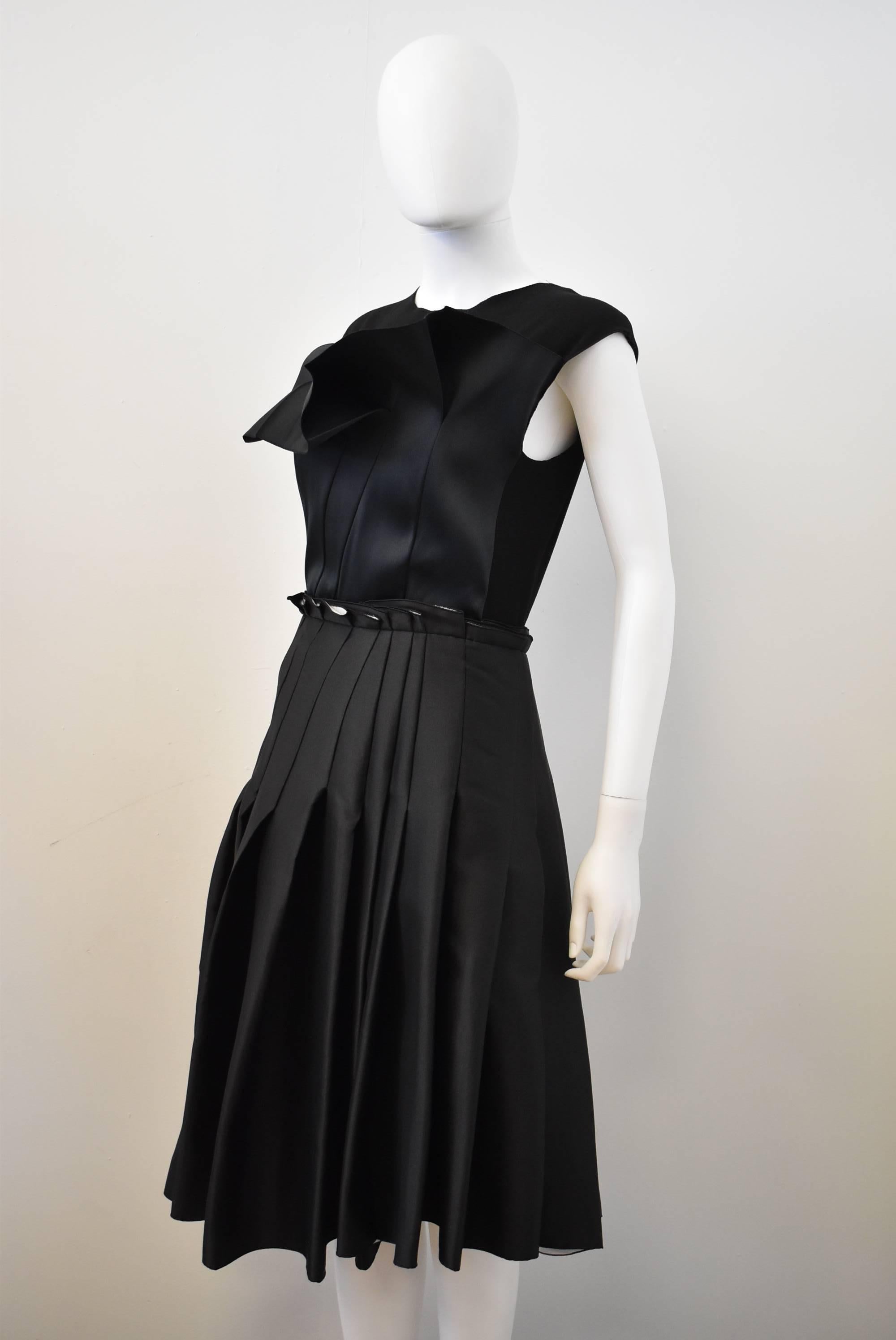 A beautiful and elegant black cocktail dress from Lanvin, designed by Alber Elbaz. The dress has an unusual ‘deconstructed’ aesthetic creating a twist on a classic little black dress. The sleeveless dress is constructed from a skirt with irregularly