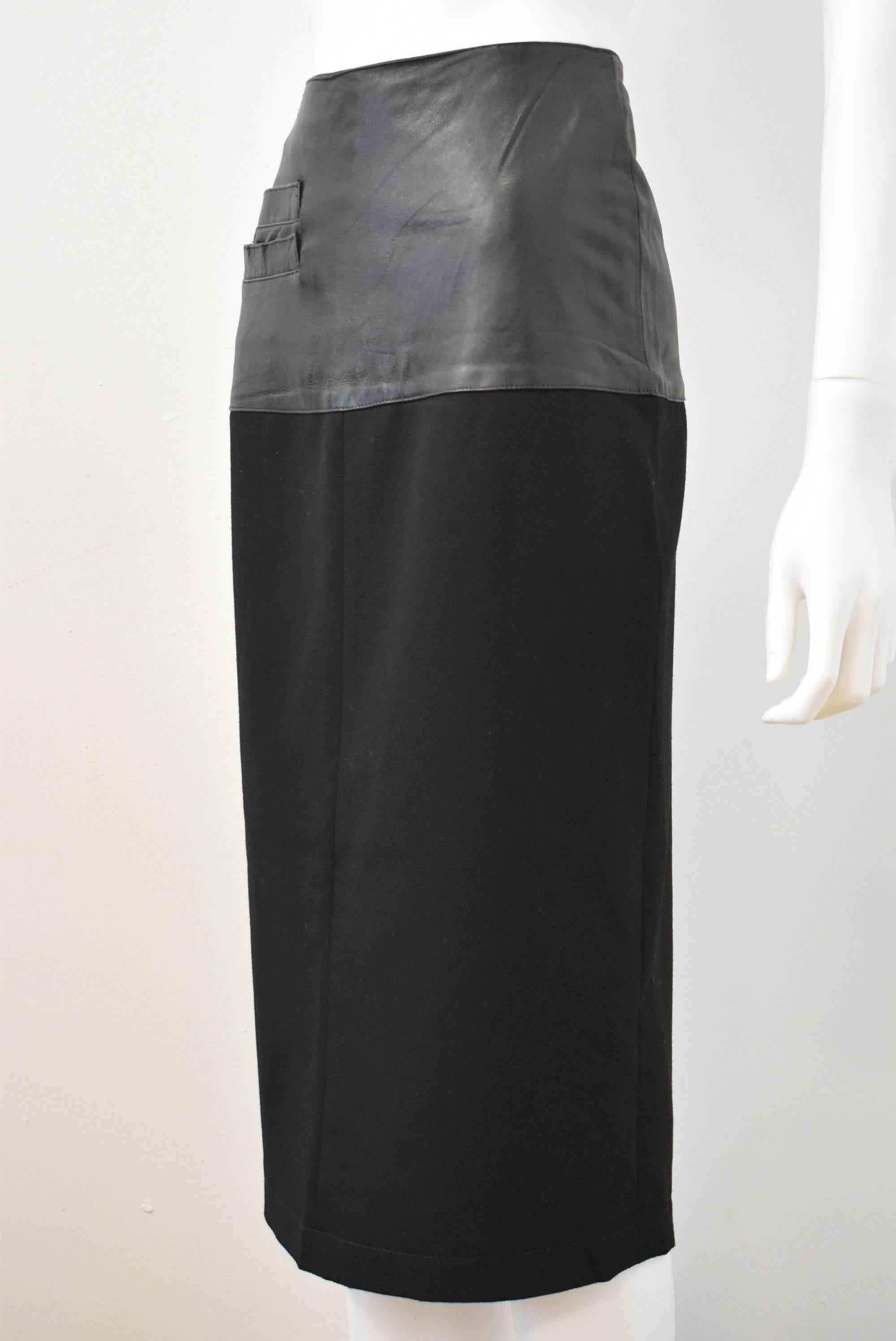 Black faux-leather and wool Claude Montana pencil skirt. The skirt has a leather panel around the waist and hips with an attached wool skirt. There is a pocket at the hip and a large slit at the back for ease of movement. It is in excellent vintage