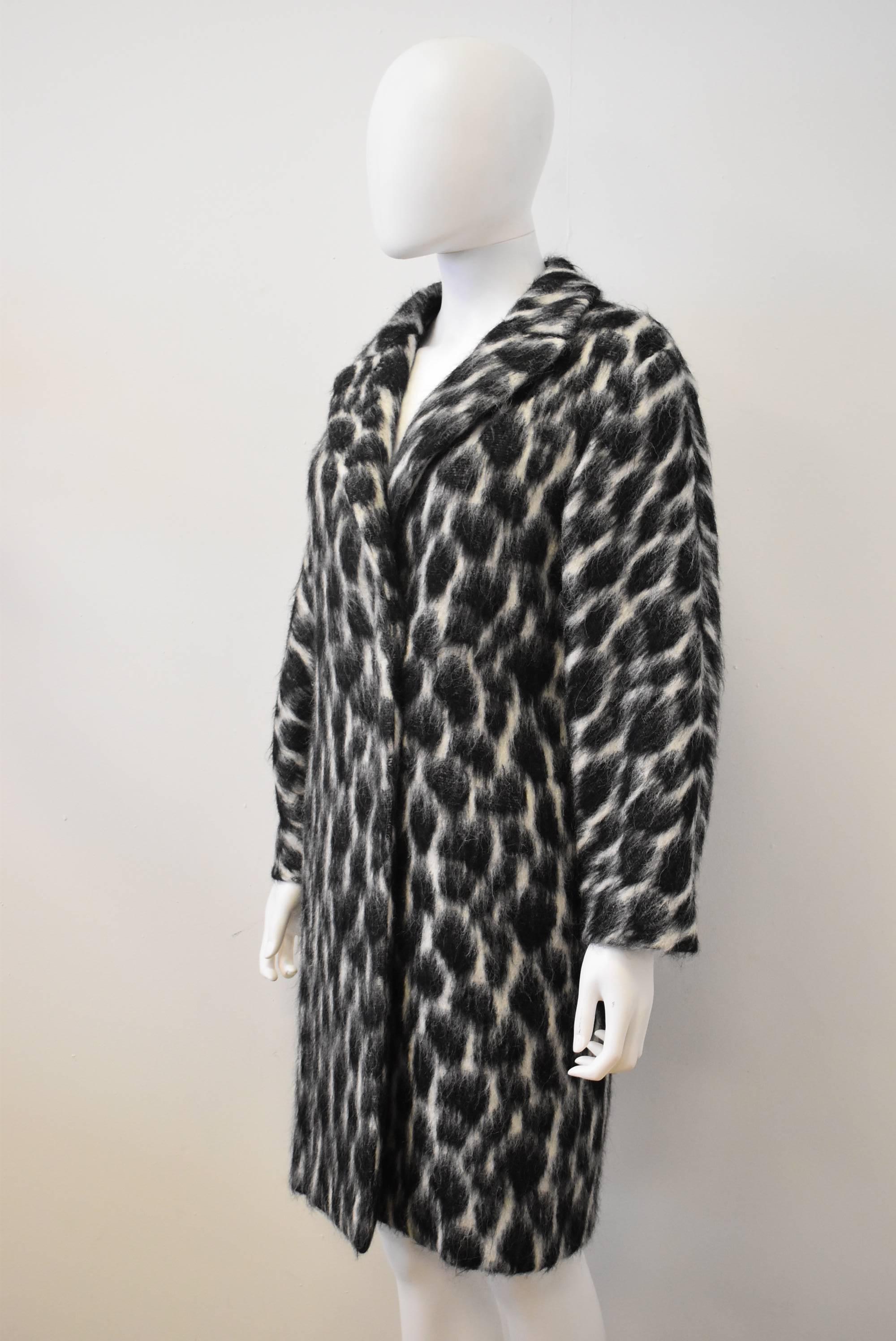 A luxurious black and white animal print coat by Gucci. The coat is made from a blend of Alpaca and Mohair which gives the coat a beautiful and unusual texture. The coat falls to just above knee length and is perfect to keep you warm during the