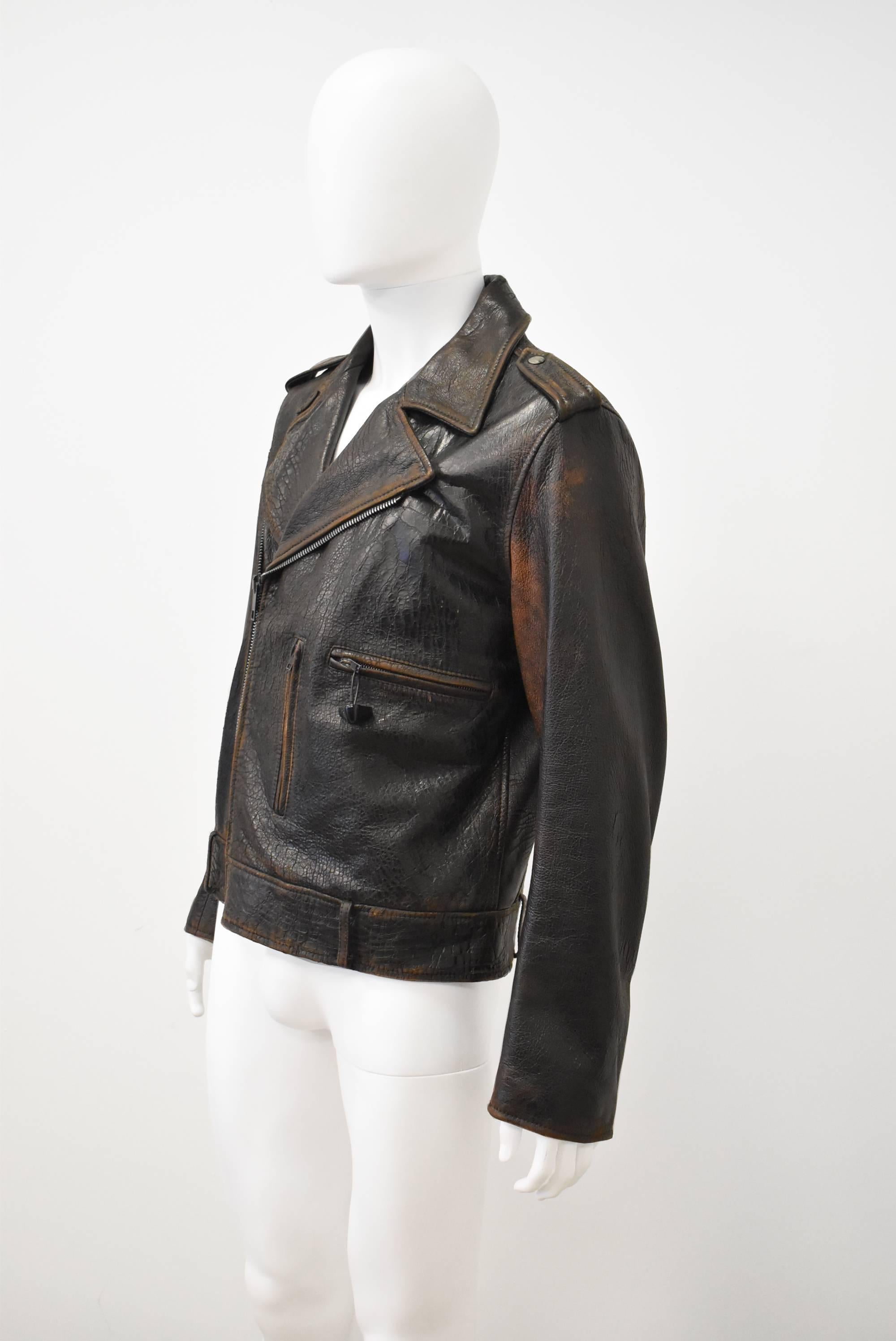 A brand new with tags dark brown leather jacket by Maison Martin Margiela. The jacket has a classic ‘biker’ shape with off-centre zip, large collar, epaulettes, and belt loops. The jacket is made from a dark brown leather with a purposefully