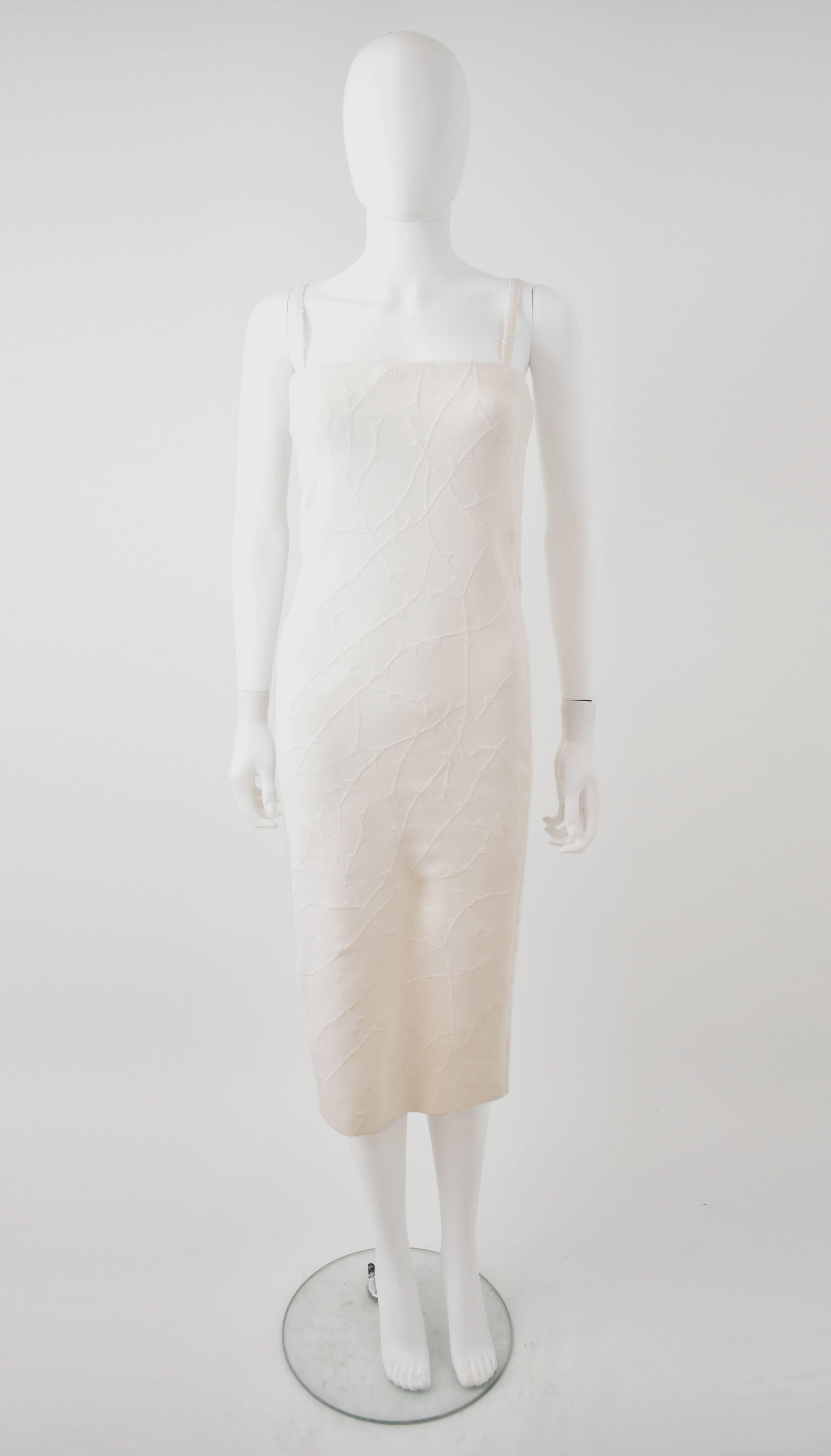 A white bodycon dress with an all-over Barbed Wire textured motif from the Spring/Summer 2010 Yves Saint Laurent collection designed by Stefano Pilati. The dress has a simple, sheath shape that fits close to the body with two thin shoulder straps