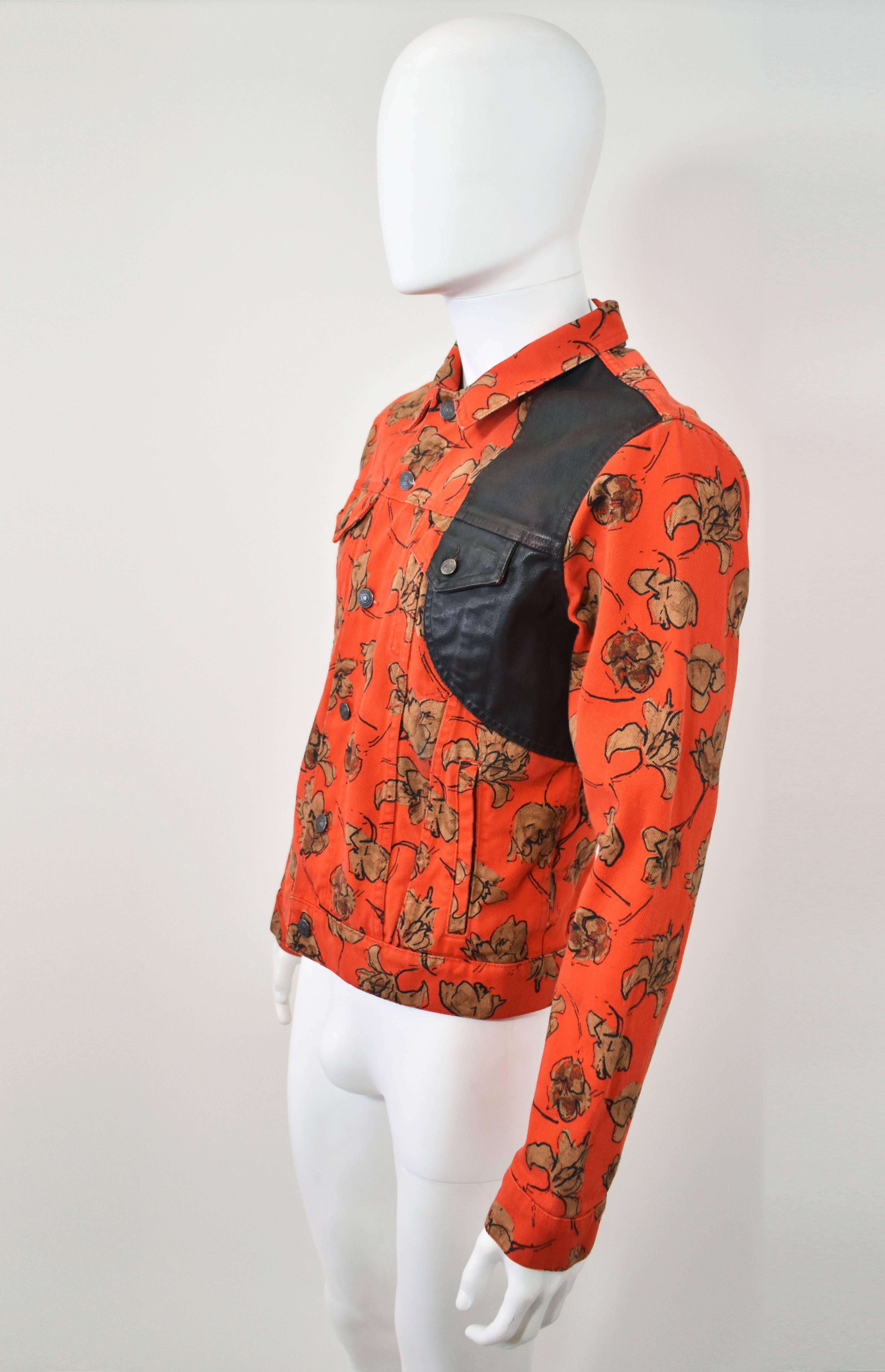 An orange floral print denim jacket with concealed belt and waxed cotton panel  by Dries Van Noten. The piece is in excellent condition

Length - 25.5
Bust - 42
Waist - 36
Hips - 37
Sleeve Length - 26