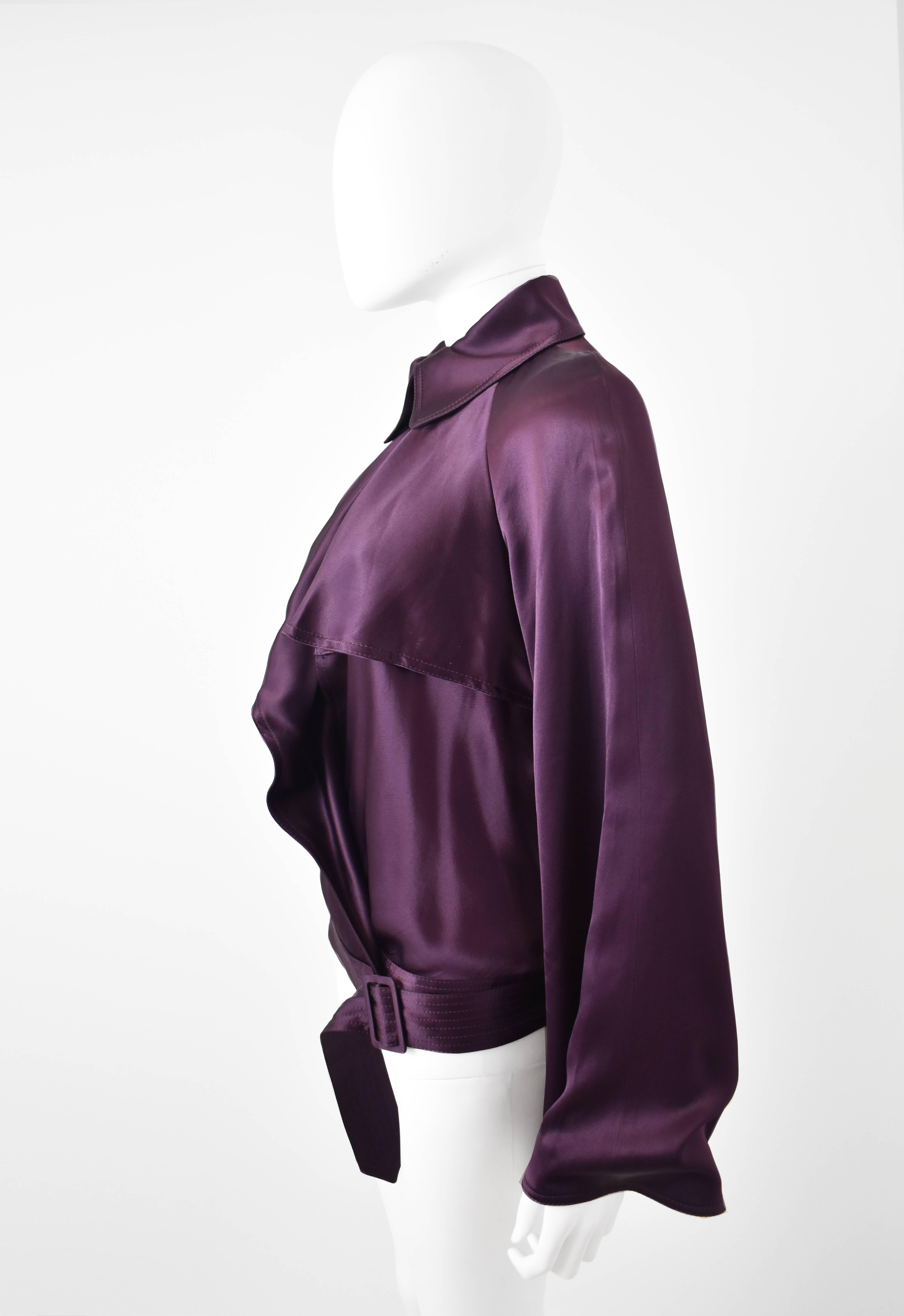 A beautiful and unusual purple top by Jean Paul Gaultier. It has an excellent shape that has a crossover, wrap-around and V-neck style. There is a belt that ties around the waist, looping through a hole in the waistband and wrapping around the