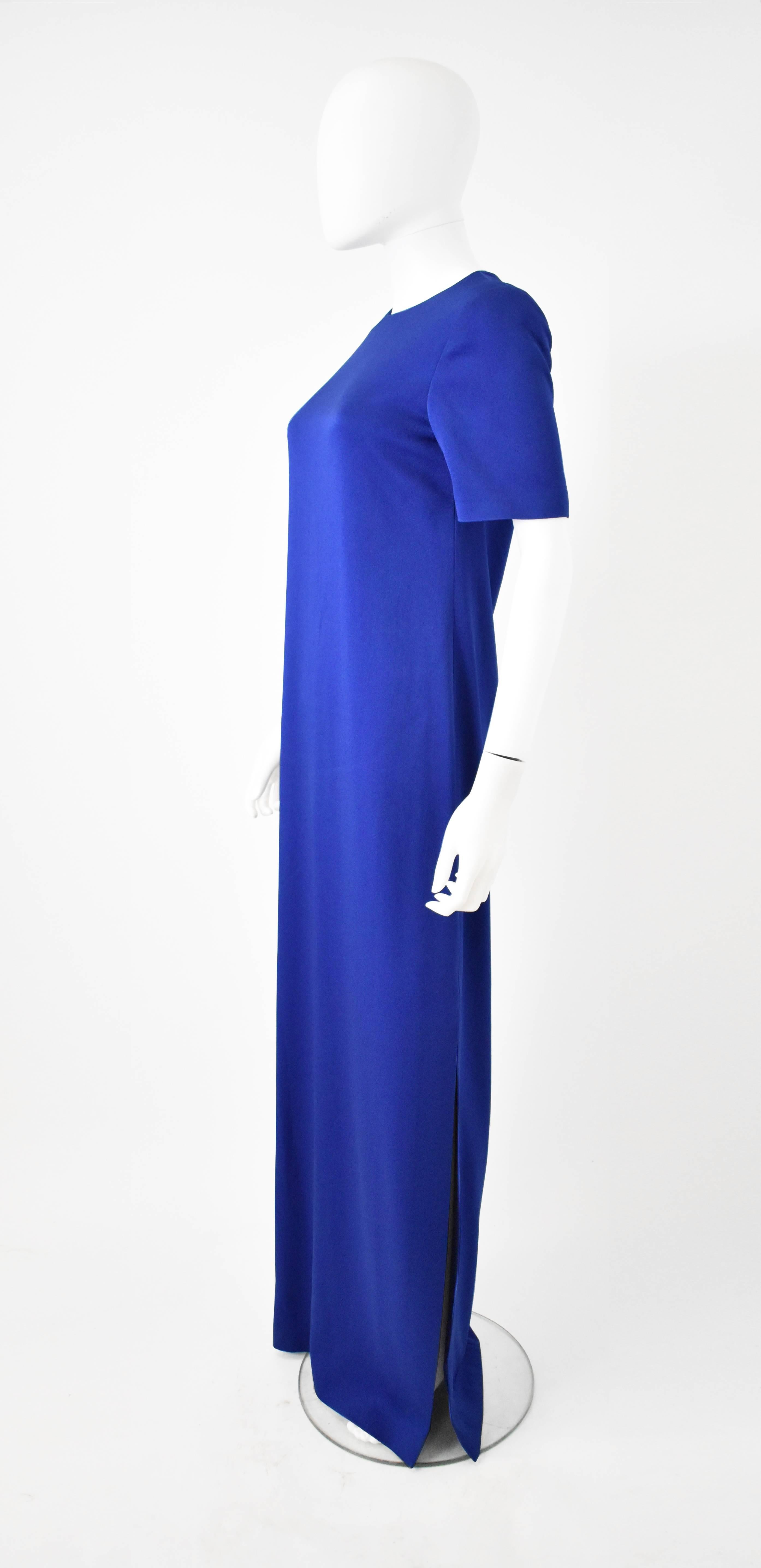 A simple and classic long evening dress by Alexander McQueen. The dress is made from a beautiful and bold royal blue colour. The dress has a crew neck, short sleeves and a T-shirt shape and straight cut. It has two dramatic thigh slits up either