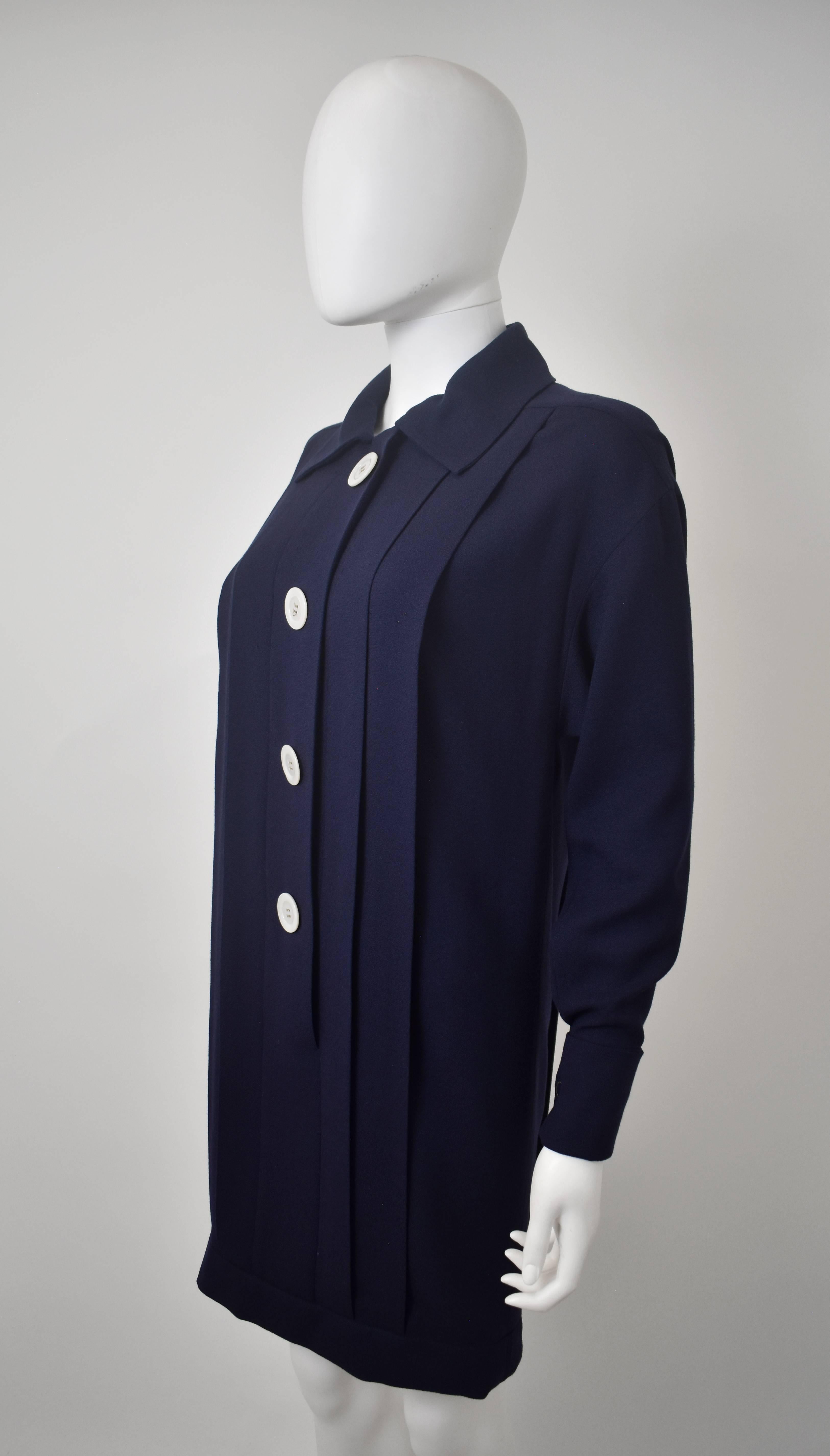 A classic Karl Lagerfeld designed Chanel dress from the 1990's with a simple, elegant shape that pays homage to Coco Chanel's 1930's resort-wear heritage. The dress is made from a navy blue wool crepe and has a straight cut with collar, front