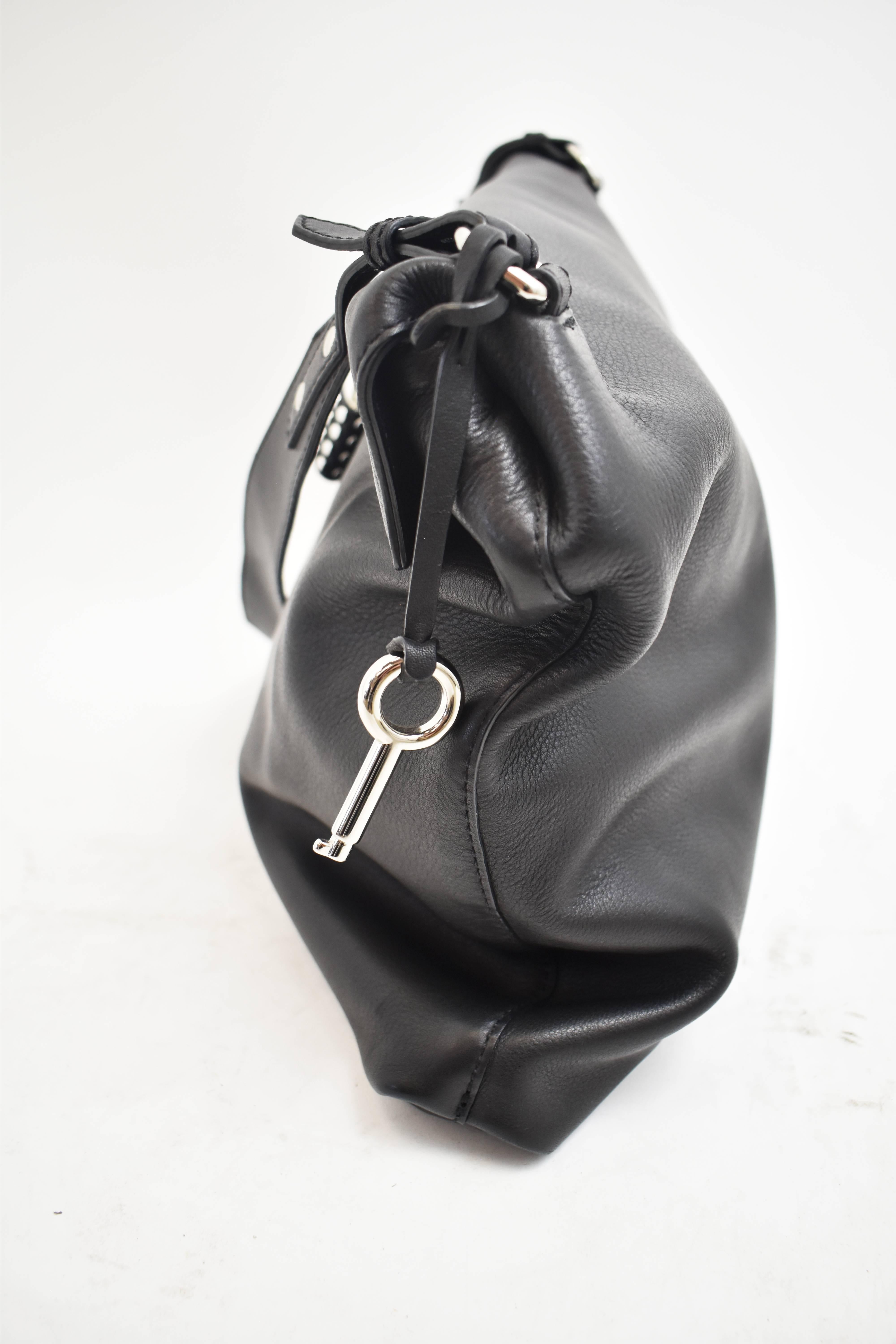 A Burberry black leather handbag with a single shoulder strap. It has a simple square shape with a fold-over fastening and magnetic clasp. The inside has a spacious interior and a zip pocket for valuables. The bag has silver hardware and a