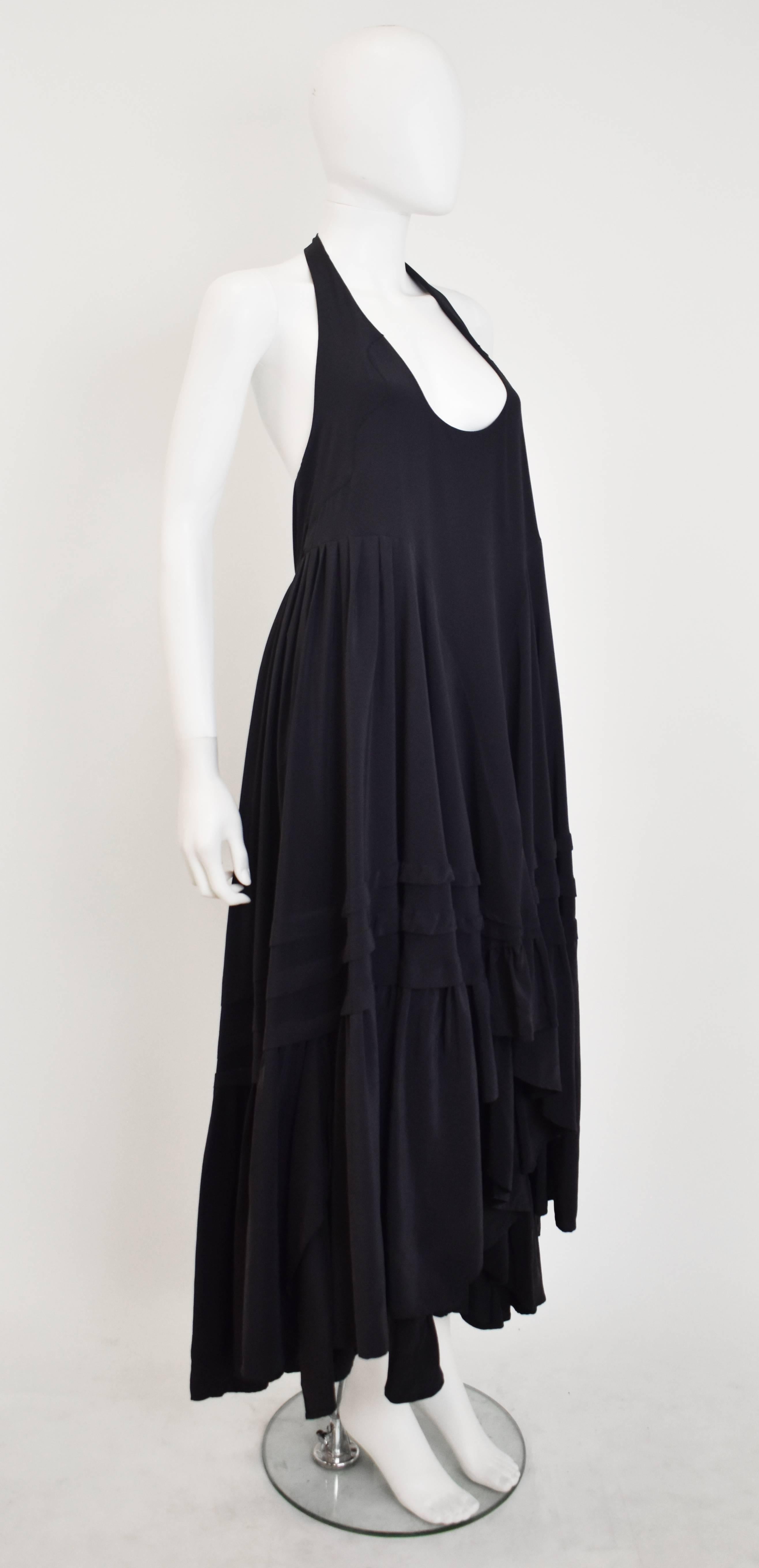 A beautiful halter neck dress from Balenciaga’s Silk label. The dress has a sleeveless, halter neck design with an elegant shape that trapezes out from under the bust. The skirt is full with ruffles that are shorter at the front and longer at the