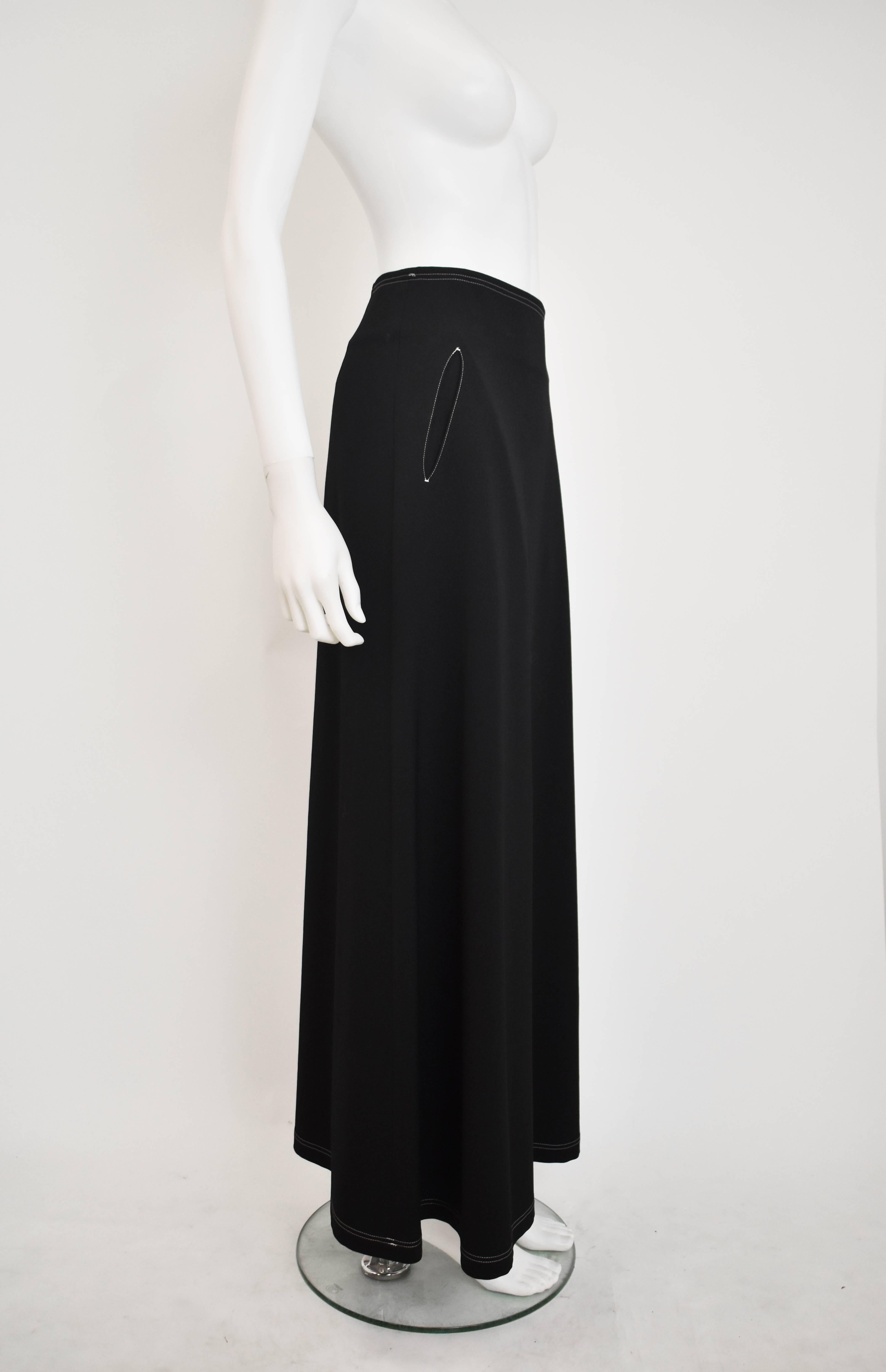 A classic black A-line skirt from Y’s by Yohji Yamamoto. The skirt has a simple shape and a longline fit. It is made from 100% black wool with white contrast stitching around the waistband, pockets and seams. The skirt features two pockets at the