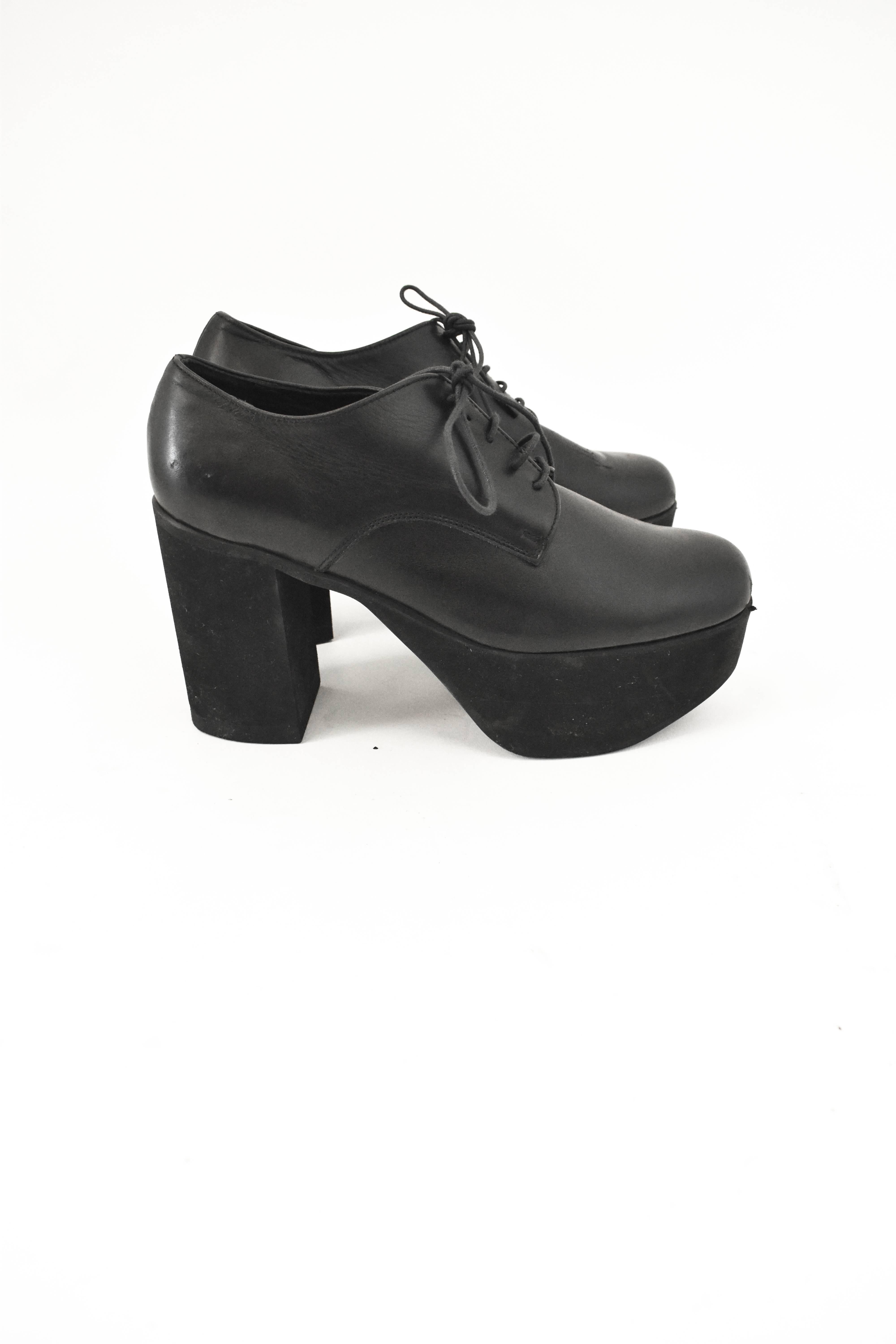 A pair of contemporary chunky black platform shoes from Yohji Yamamoto. The shoes are made from a soft black leather and lace-up fastening with a chunky 2 inch rubber platform sole and 4.5 inch heels. The shoes have been worn but are in good used