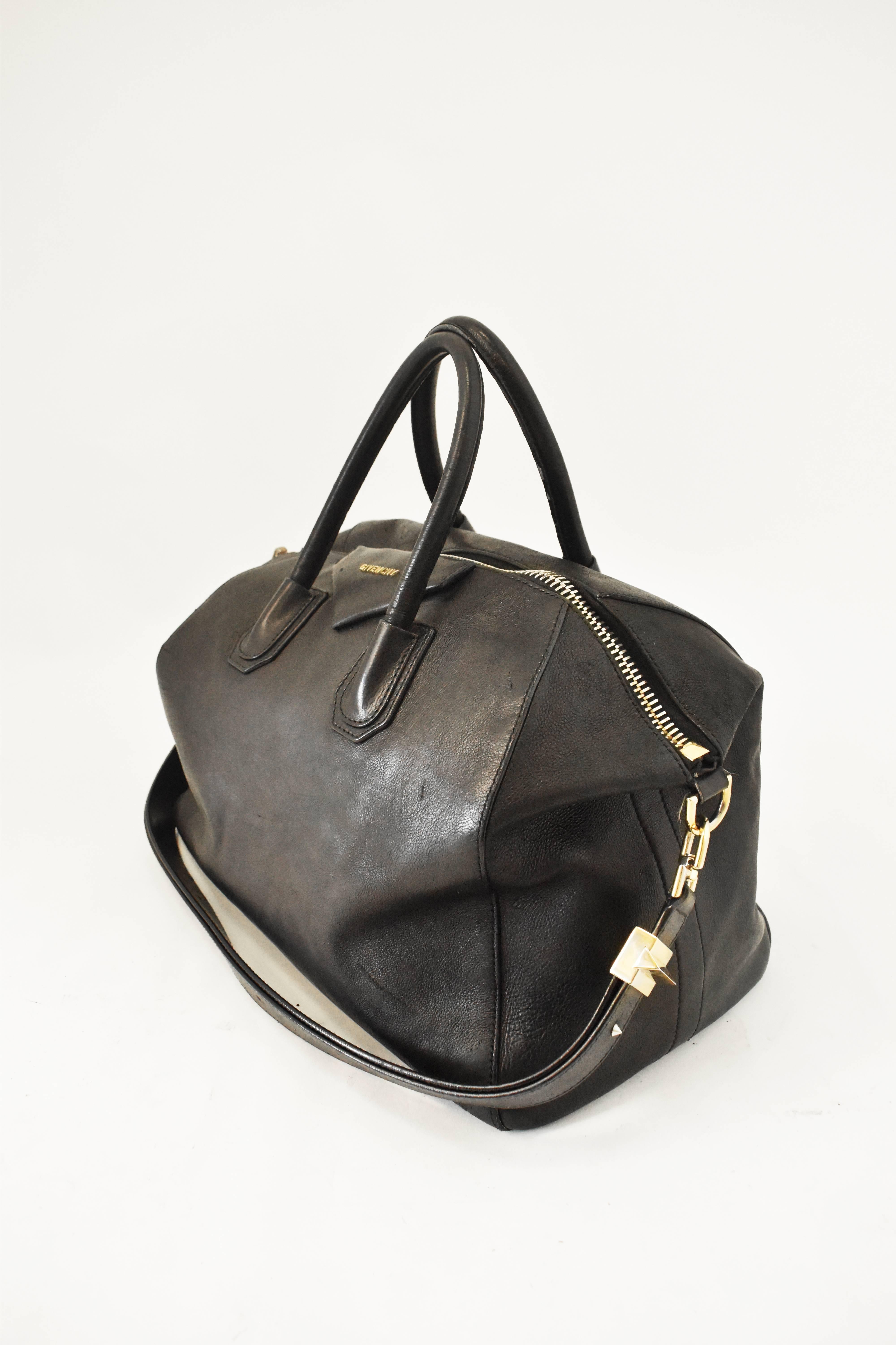 A medium sized leather handbag from Givenchy. It has a boxy doctor’s bag sort of shape with two top handles and large zip across the top. It also has a shoulder strap with gold hardware that can be lengthened and worn across the body. The bag is
