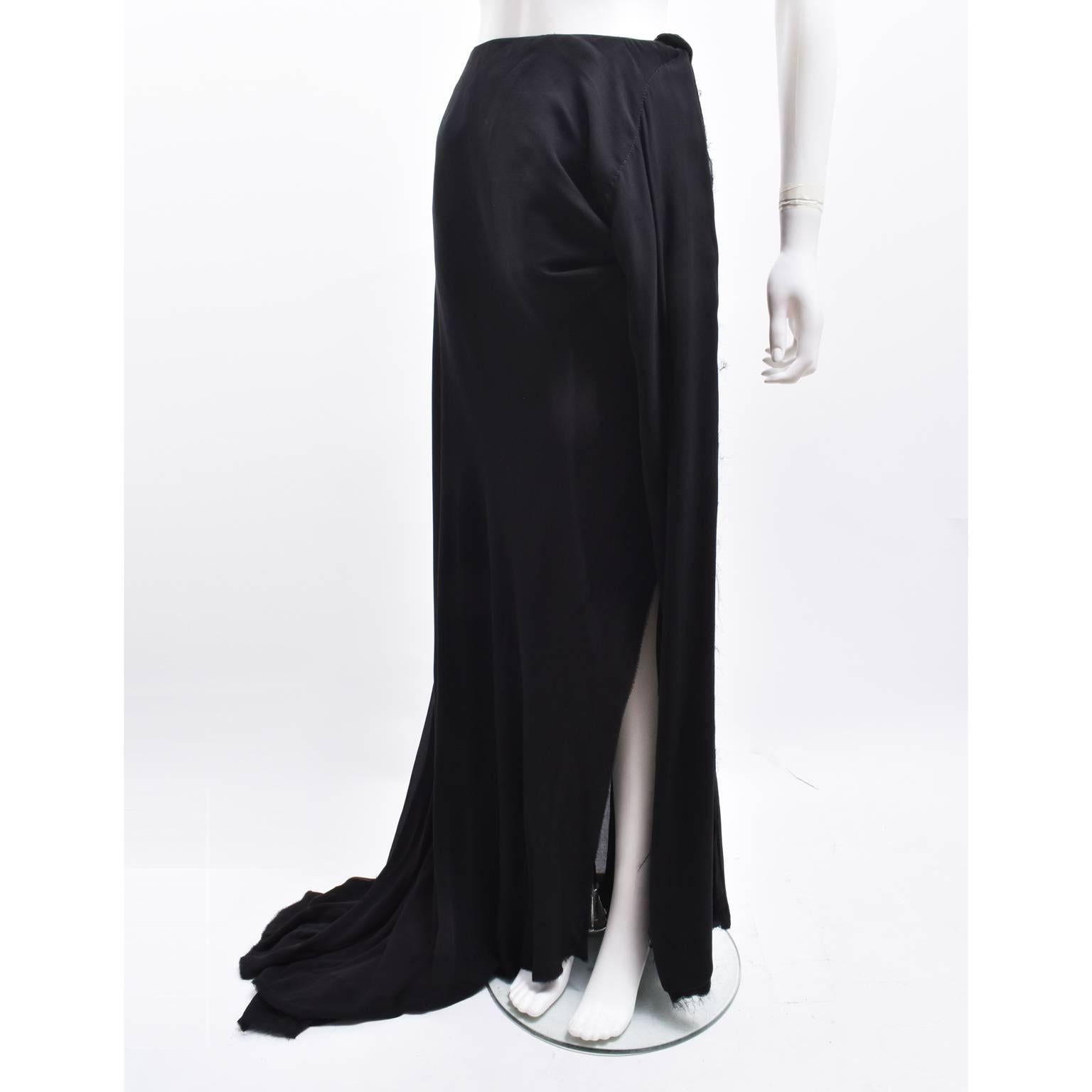 A beautiful long draped skirt by Vivienne Westwood. The ‘Acorn’ skirt sits on the waist and flows down to floor length with elegant draped folds. The skirt has an asymmetric shape with a side slit and a knot at the top of the slit that creates