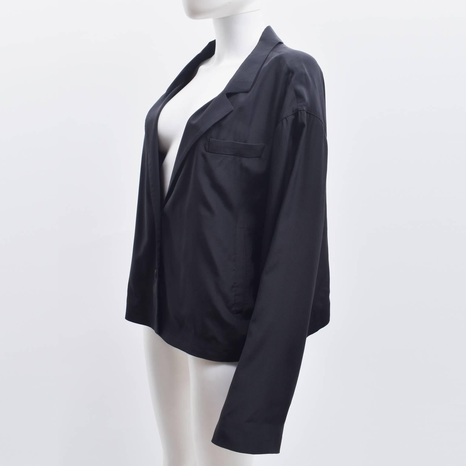An elegant black silk jacket from Prada. The jacket has a boxy, cropped, oversized shape that is a contemporary twist on a classic garment. It is made from 100% Silk and is extremely light in texture and style. It is in excellent condition. 