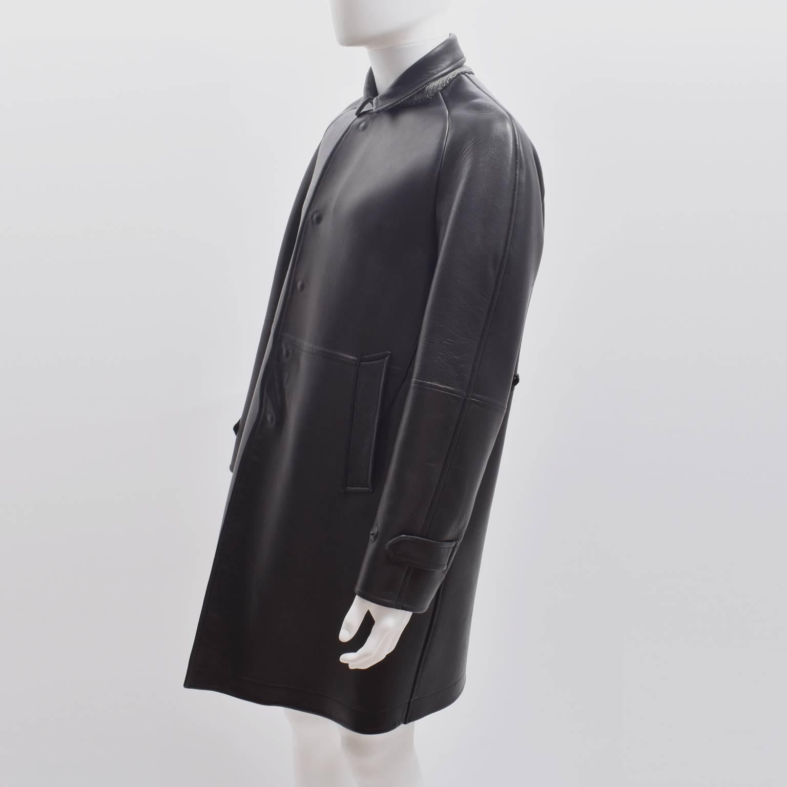 A black leather long coat from British heritage line Burberry Prorsum, the runway collection of the luxury brand. The coat has a simple and elegant straight shape, with rounded shoulders, popper fastening and two large pockets. The back features 