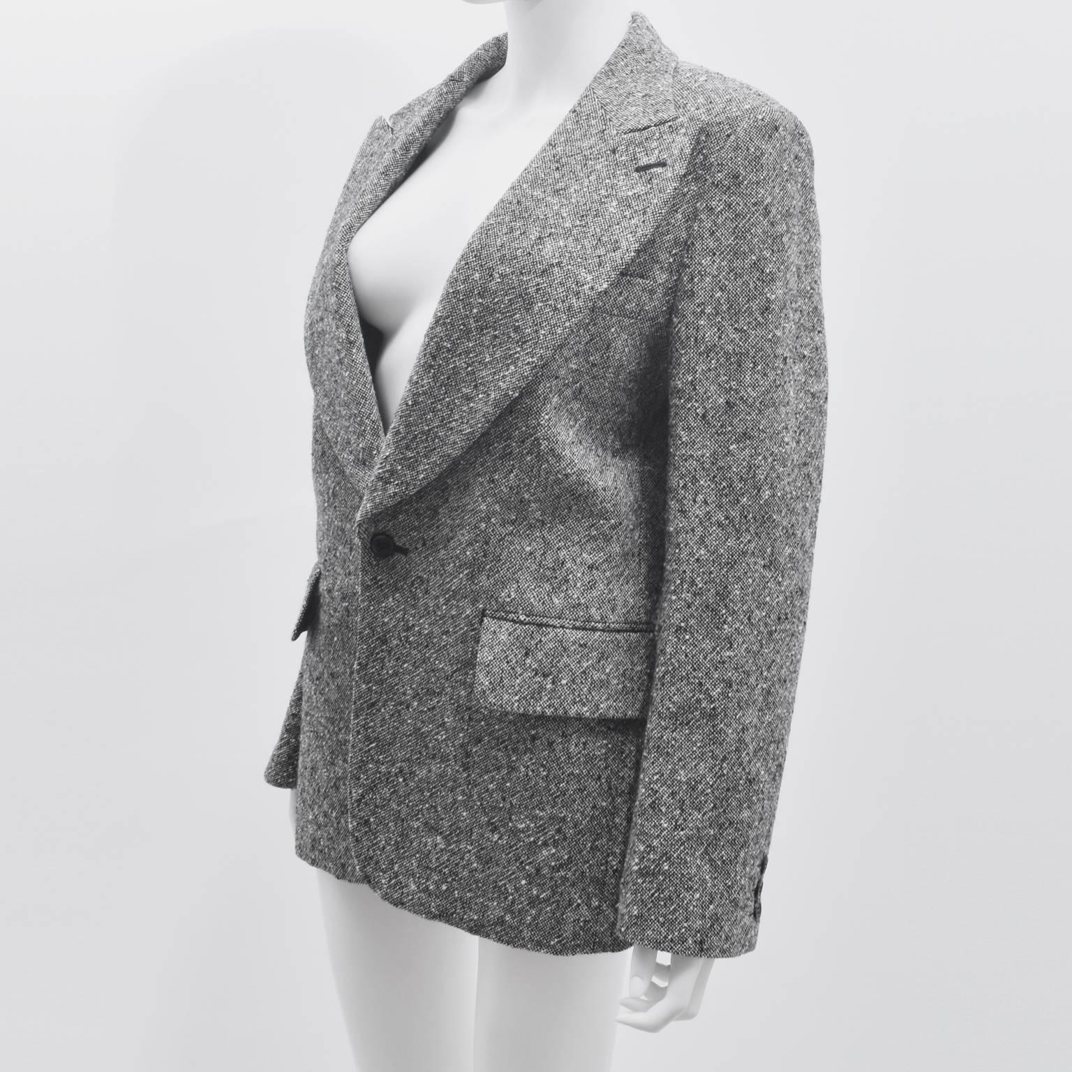 A Comme des Garcons grey and white wool tweed sports jacket from 2001. The jacket has a boxy, straight cut in a relaxed sports jacket style. It is made from a wool and nylon blend of grey and white creating a woven, textured material. The jacket is