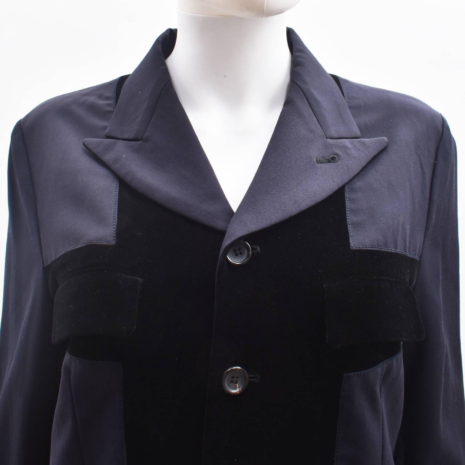 A classic Comme des Garcons navy blazer with contrast velvet panels. The jacket has a simple, straight shape, with notched collar, button fastening and flap pockets at the bust and hip. The velvet panels are stitched in a cross shape across the