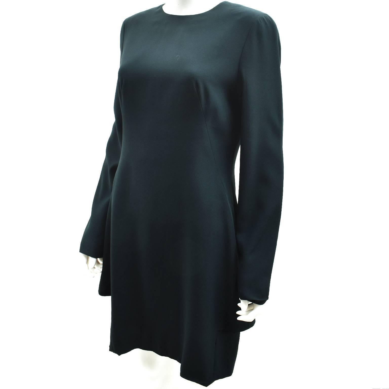 A beautiful long sleeved dress in an unusual teal colour from Alexander McQueen. The dress has a fairly straight silhouette that nips in at the waist and falls just below the knees. It also has an interesting faux double layer from the back that