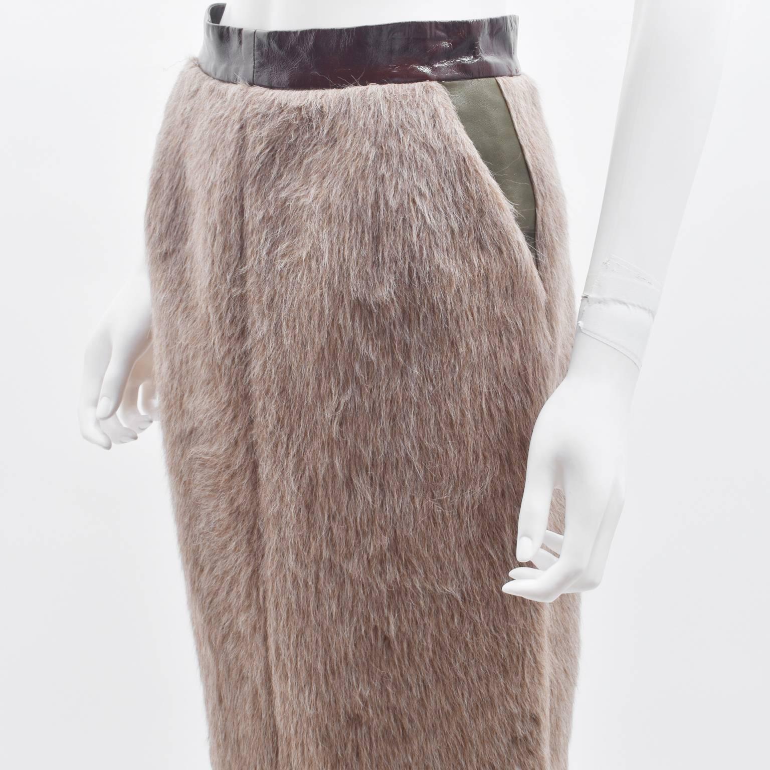 A beautiful Winter skirt from Celine’s A/W 2011 collection. The skirt has a simple A line shape with a high waisted fit. It has a Maroon patent leather waistband connected to the camel coloured faux fur skirt. It also features khaki leather pockets
