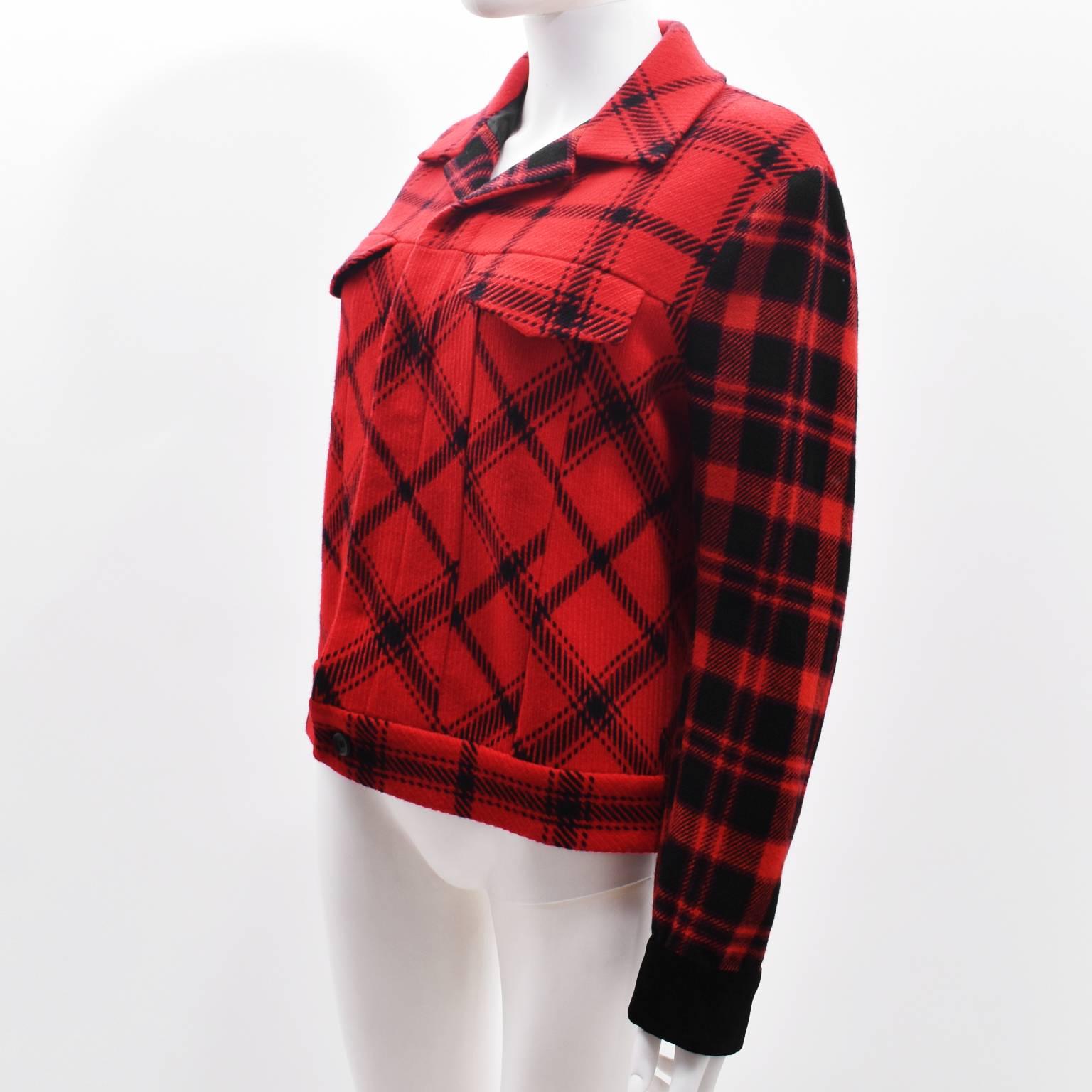 A vibrant and beautiful red and black check print jacket by Yohji Yamamoto. The jacket has a cropped, boxy shape with long sleeves, notched collar and two flap pockets on the chest. It is made from a warm wool and nylon blend, with a diamond design