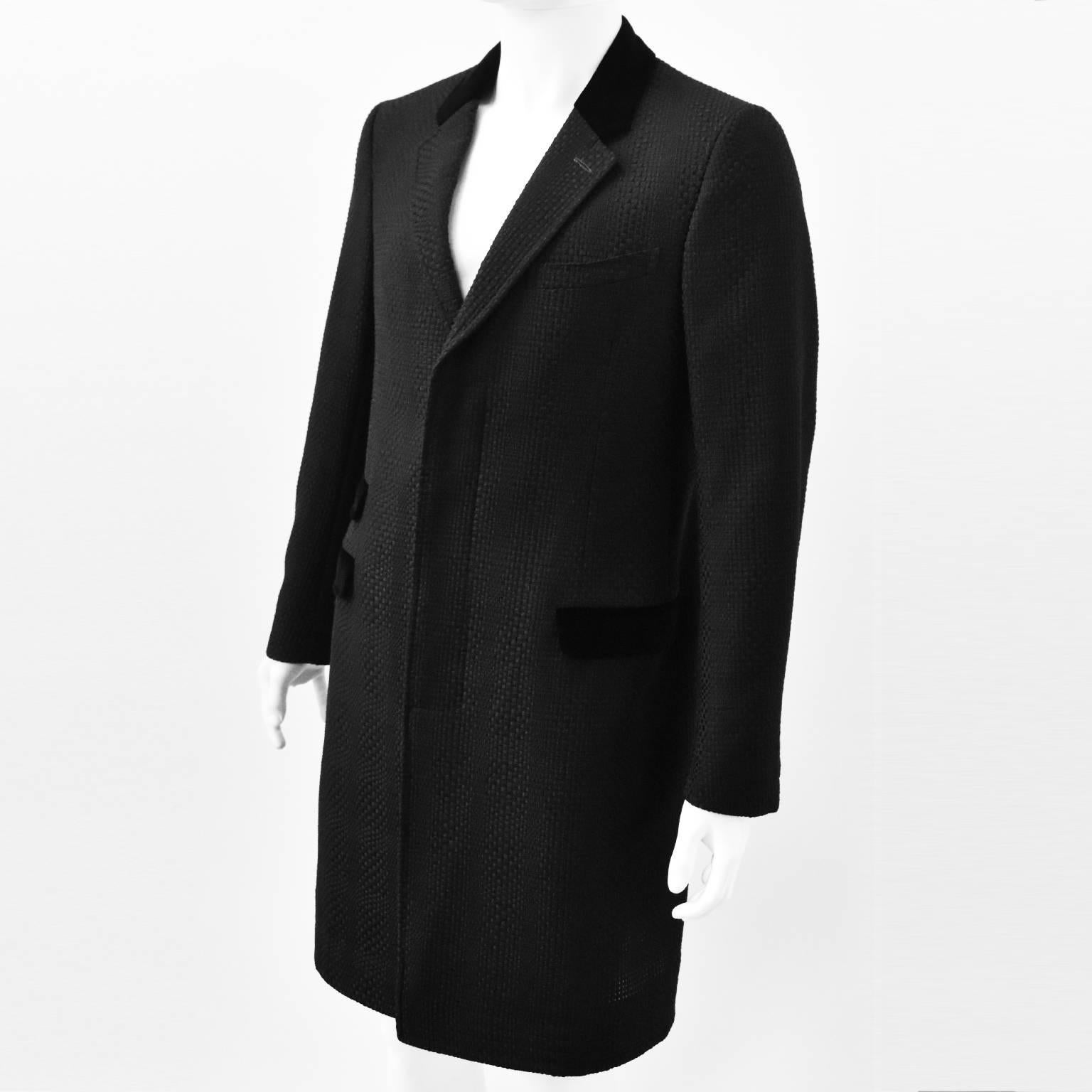 A stunning woven coat from Alexander McQueen’s Spring Summer 2016 menswear collection. The coat has an elegantly tailored shape with notched collar, concealed button fastening, slight nip in the waist and knee length. It is made from a black
