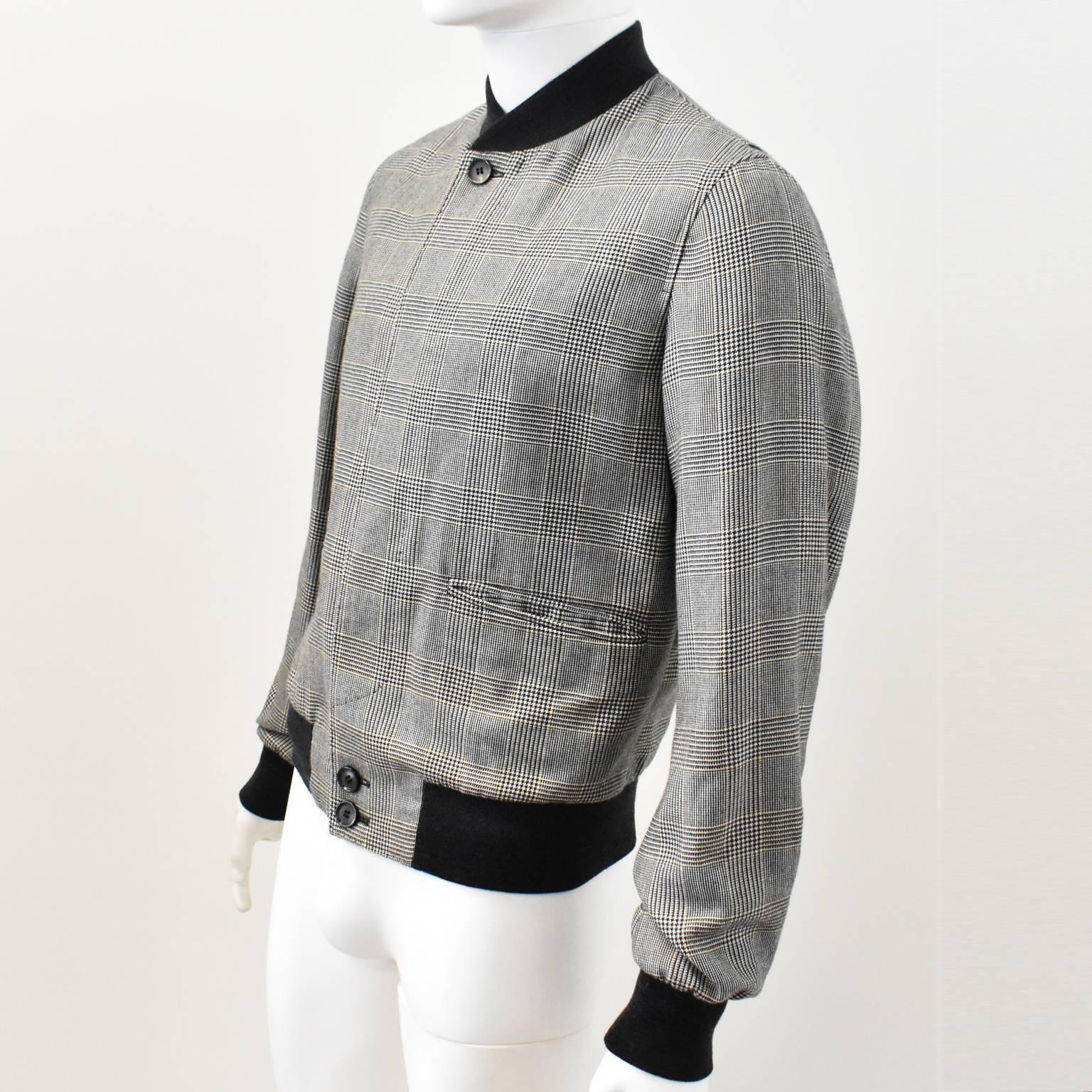 A luxurious cashmere bomber jacket from Alexander McQueen’s Autumn Winter 2014 menswear collection. 
The jacket is made of 100% cashmere that has been woven into a grey and black Prince of Wales check pattern. The jacket has a classic blouson/bomber
