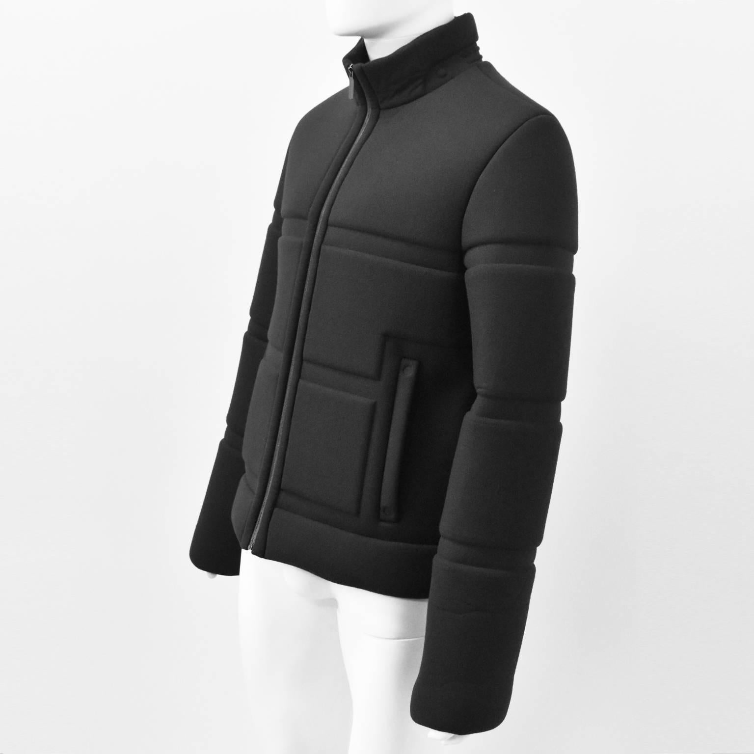 A modern and unusual structured grey jacket by Calvin Klein. The jacket is made from a neoprene style, padded material that is a wool and polyamide blend. This creates an unusual  structured shape that looks geometric but is still flexible. The