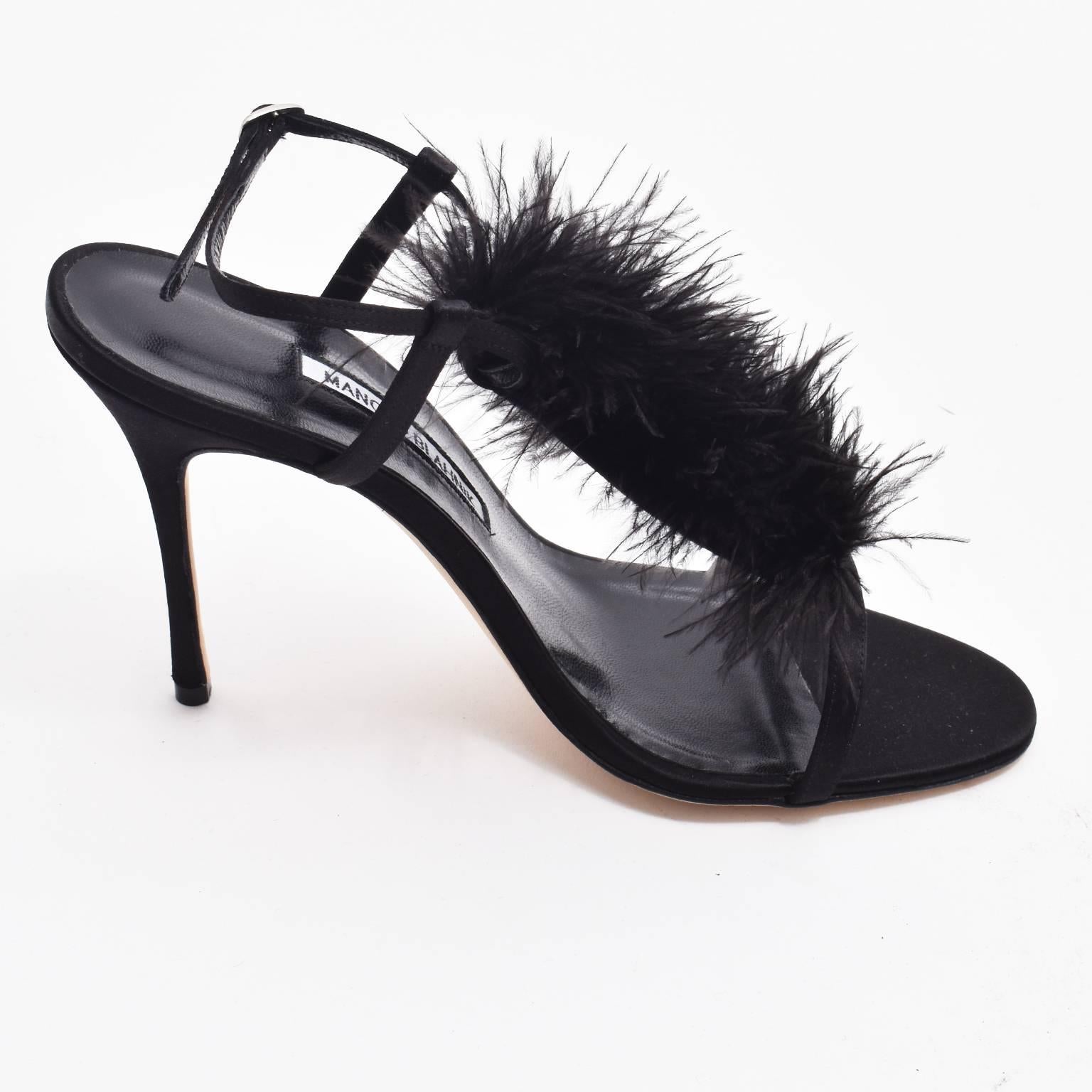 A pair of brand new and unworn black stiletto heels with feathers by iconic shoe designer Manolo Blahnik. The ‘Eila’ shoes are made of black leather with satin base, and elegant , strappy design. The shoes have a T-bar design with central vertical