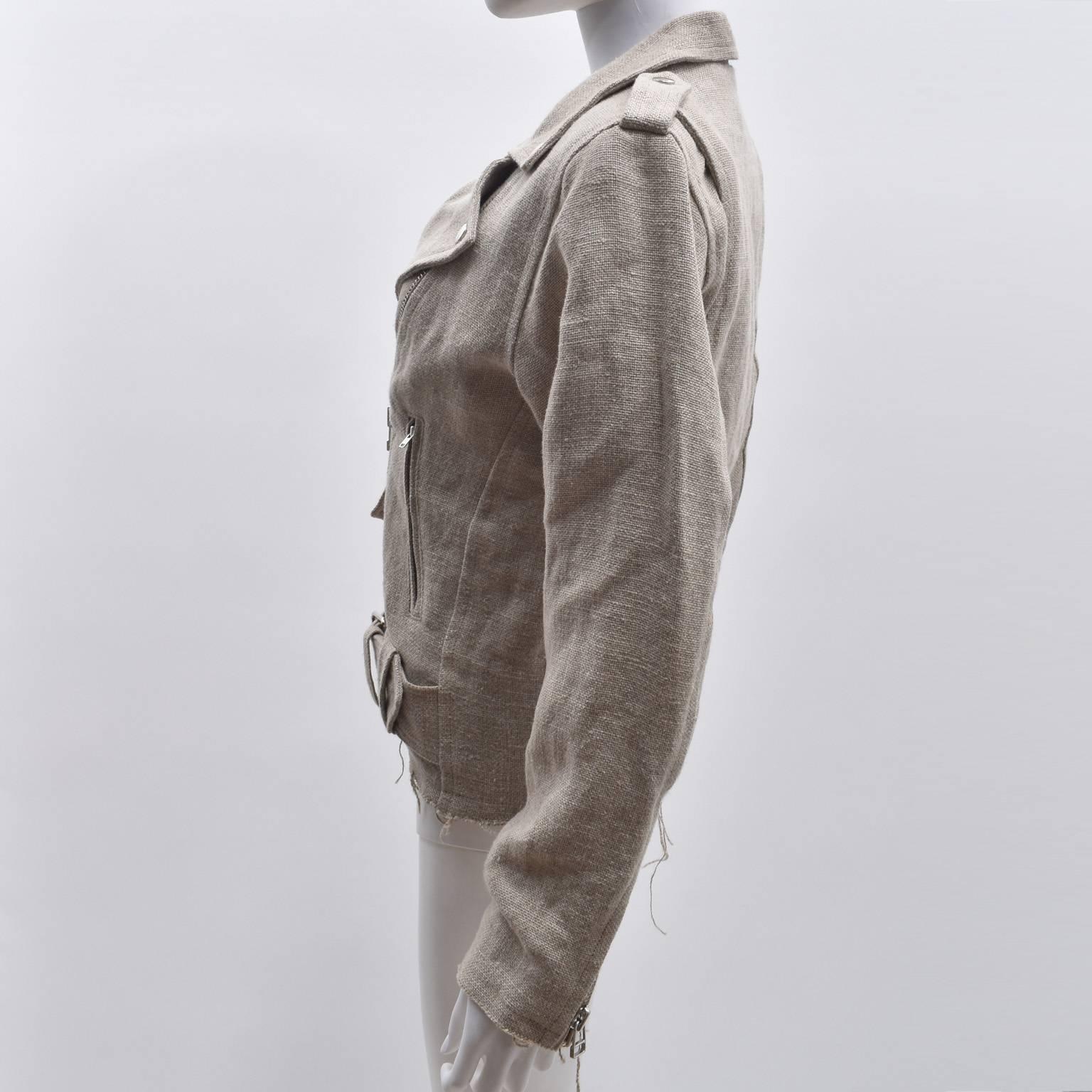A beige raw linen jacket that is a beautiful twist on a classic biker jacket from British label Marques Almeida. The jacket has a typical biker jacket design with cropped shape, notched collar, asymmetric zip fastening, belt with buckles and