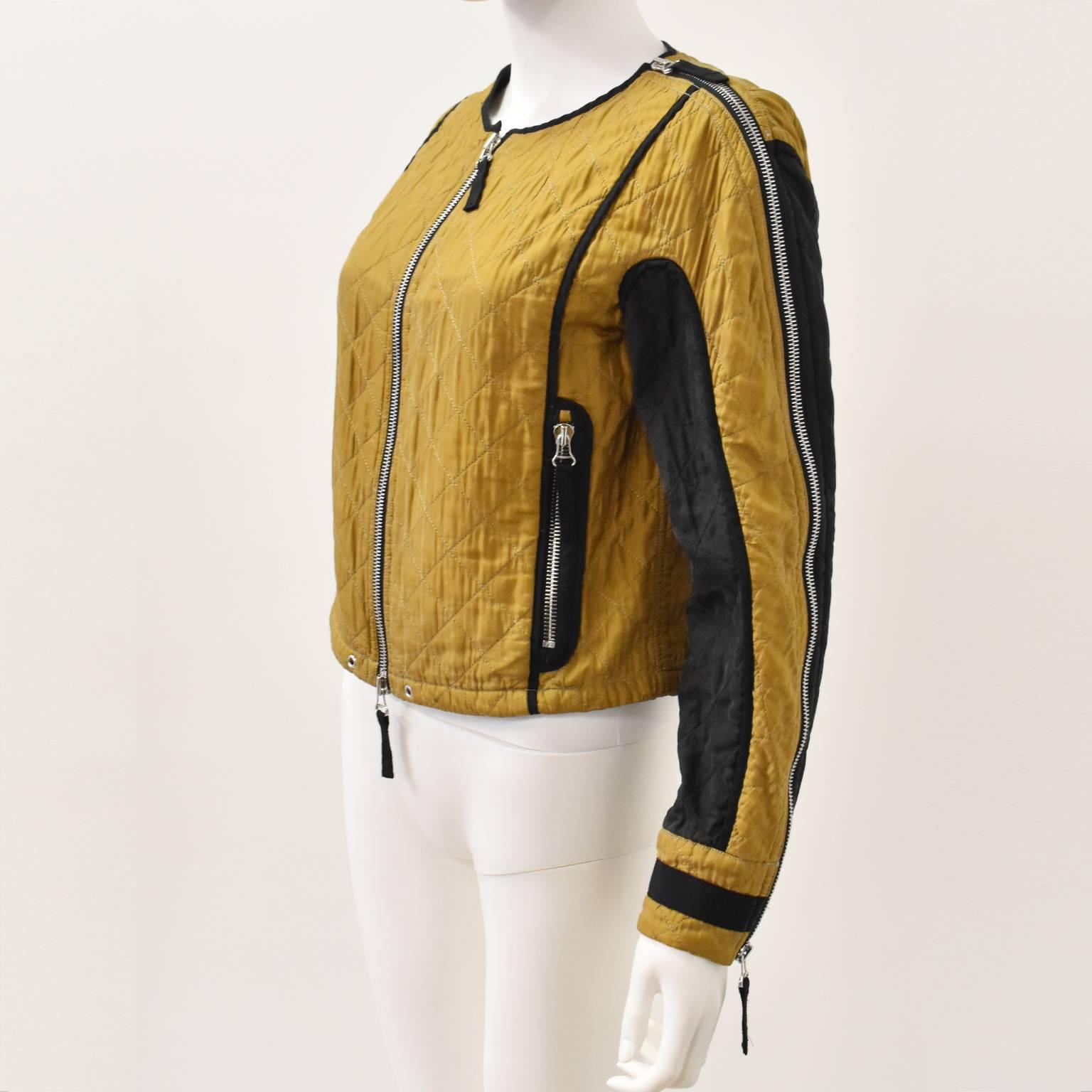 A stunning quilted jacket from Belgian brand Dries Van Noten. The jacket has a cropped shape with long sleeves, round collar and zip fastening. It is constructed from yellow quilted cotton with contrast black panels along the sleeves and black