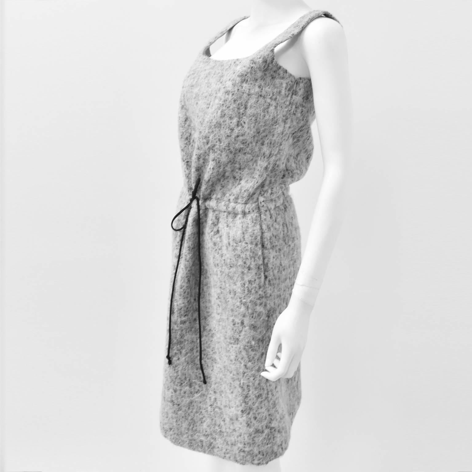 A beautiful Winter dress from Japanese fashion designer Junko Shimada. The dress is made from a textured, thick wool blend and has a simple and modern silhouette. It has a sleeveless design with round neck, and A-line shape that can be cinched with
