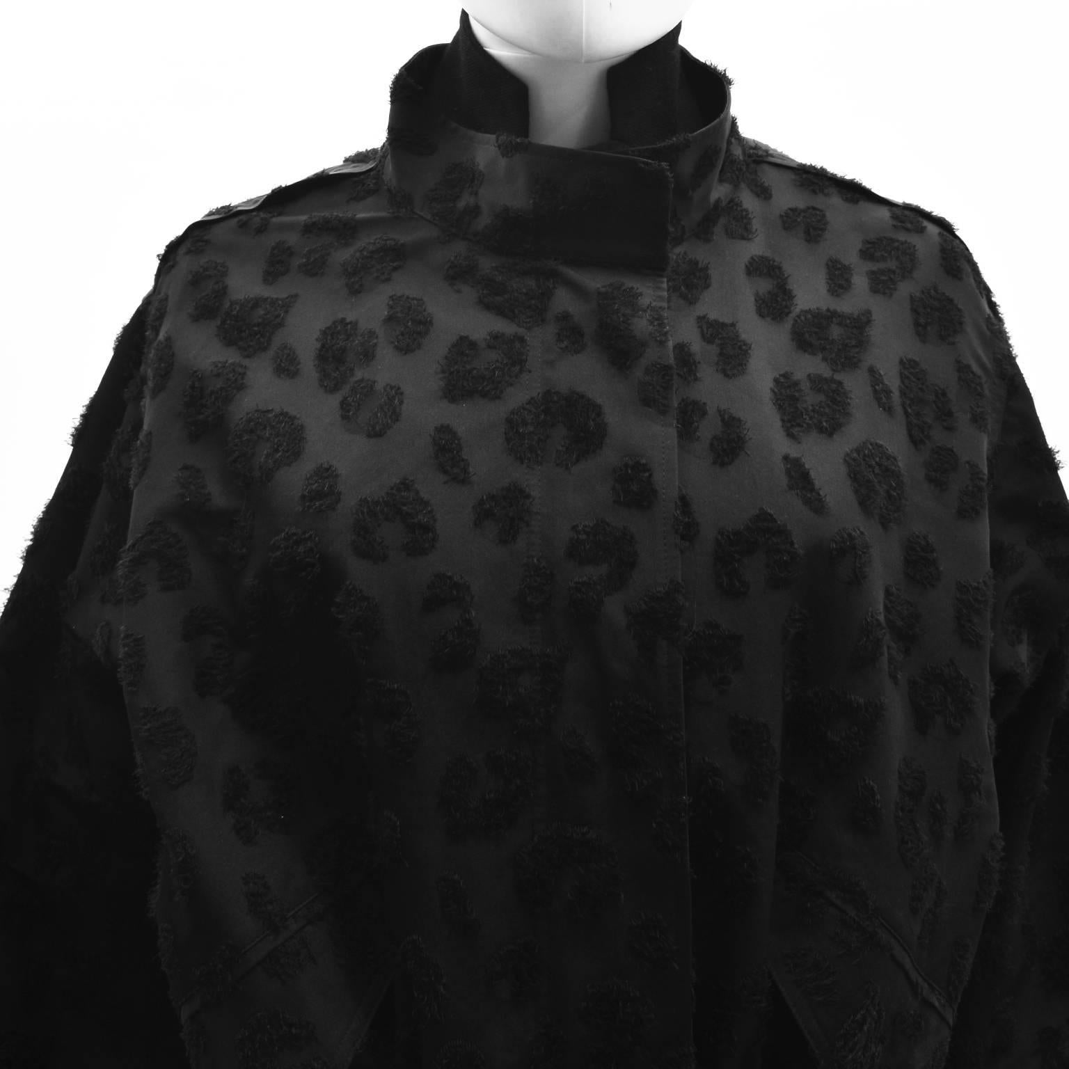 A unusual and sporty black coat from Phillip Lim with a double layer design. The coat is made from a black outer layer with an all over textured fluffy leopard print design and a second thinner layer on the inside that is attached with a zip along