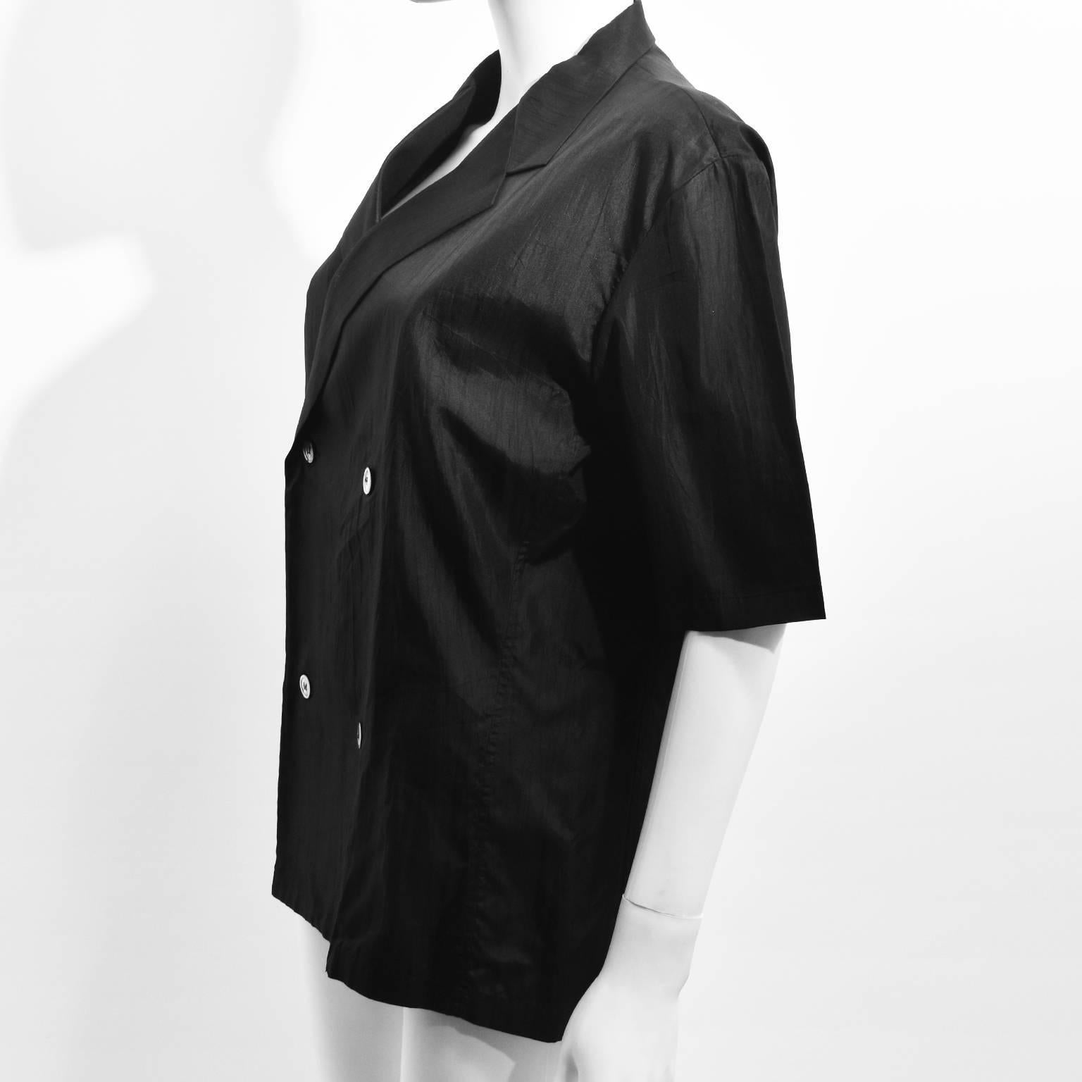 A black silk double-breasted shirt by Yohji Yamamoto featuring short sleeves and a boxy fitted cut. A size M, the shirt is in perfect condition.