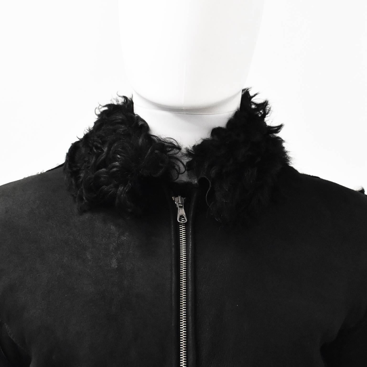 An unlabelled black Belgian shearling coat. It features a zip fastening, flared sleeves and shearling trimmings. It can be reversed and worn with the shearling as the outer fabric but the zip would have to be pulled from the inside of the jacket. It