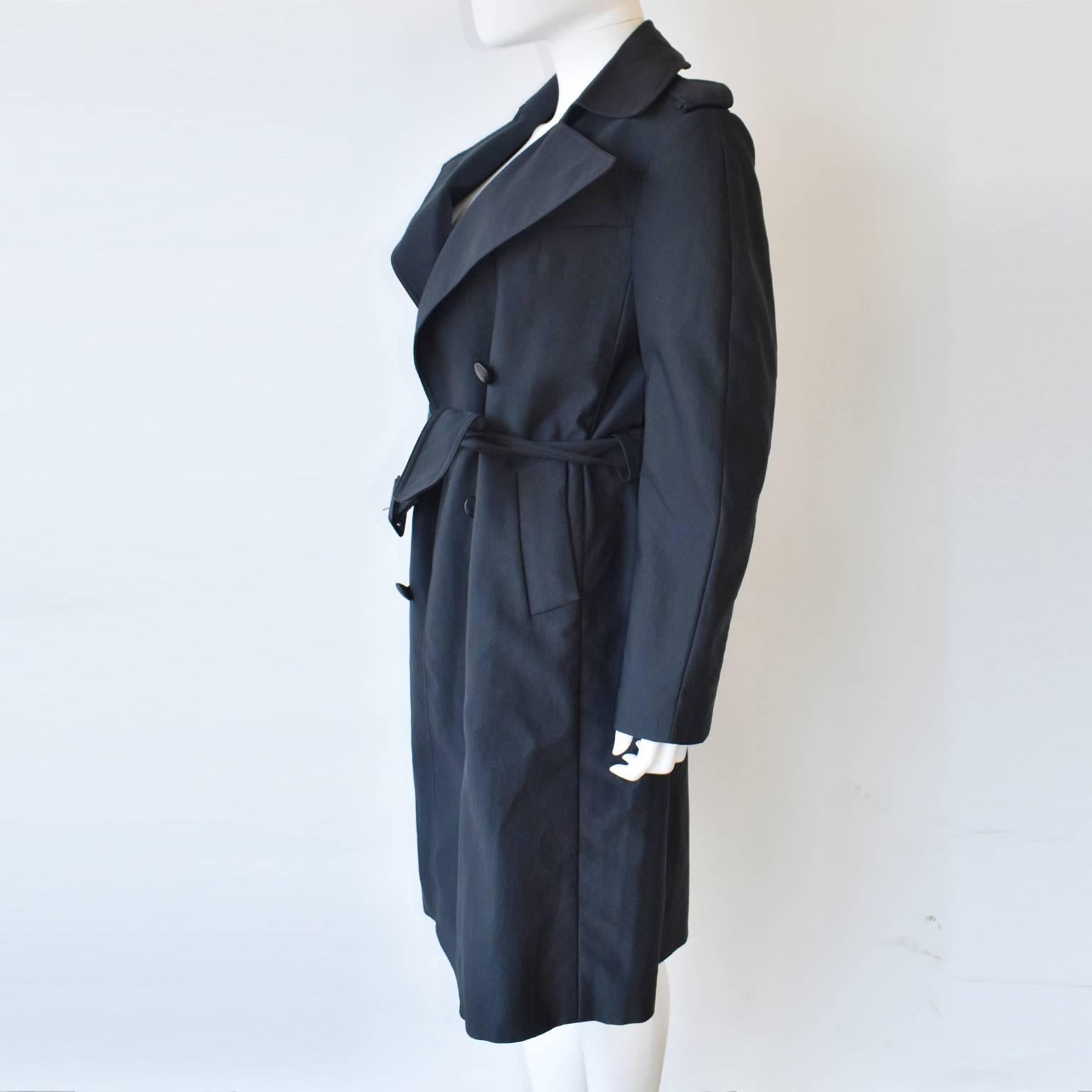A charcoal grey trenchcoat with leather buttons by Céline. The buttons are decorative; the coat is fastened with the belt which has to be tied in a knot. 
The coat is a sample, there is no care label.  It is in excellent condition. 