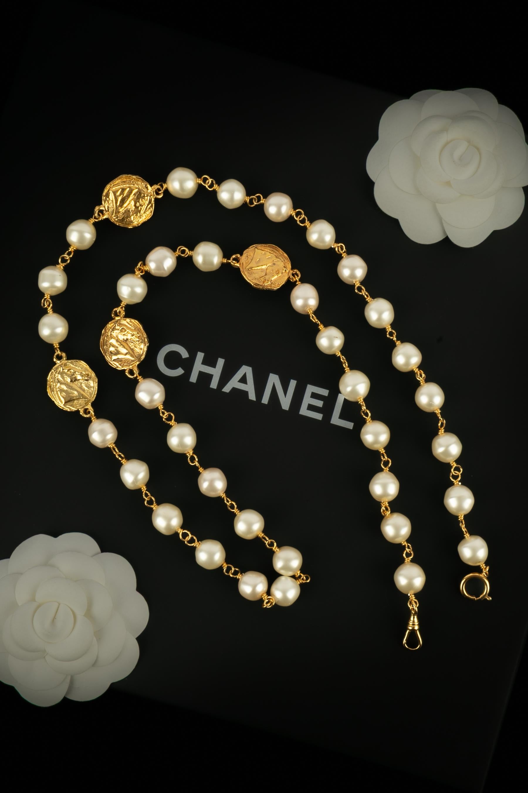 Chanel - (Made in France) Collana sautoir di perle in costume intervallate da monete in metallo dorato battute e incise.

Condizioni:
Ottime condizioni

Dimensioni:
Lunghezza: 93 cm

SKU:CB104