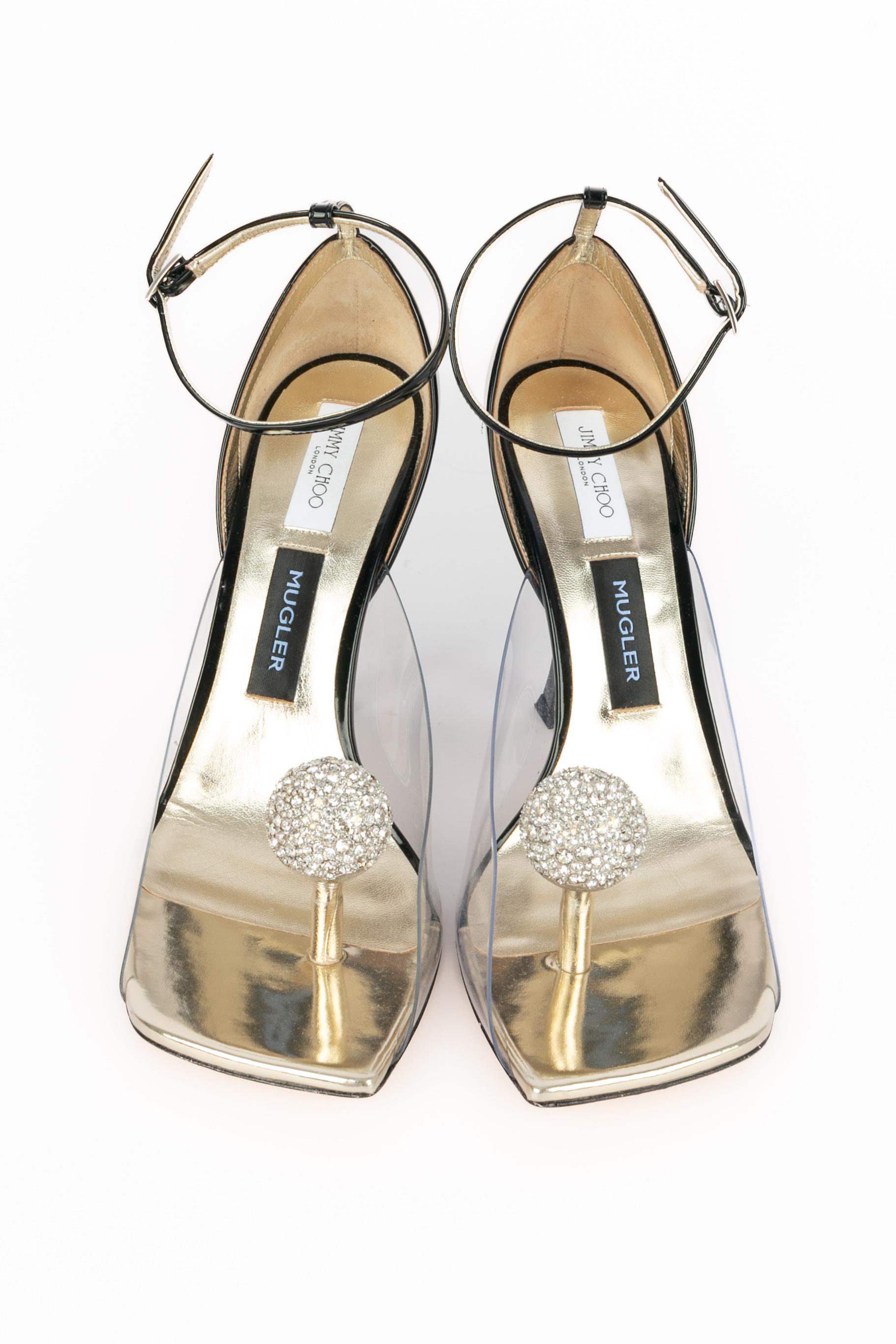 JIMMY CHOO - (Made in Italy) Scarpe a spillo in vernice nera con bordi trasparenti, interno in pelle dorata e metallo dorato strassato. Indicata la taglia 41IT. Una Collection'S 2022.

Condizioni:
Ottime condizioni

Dimensioni:
Altezza del tacco: 11