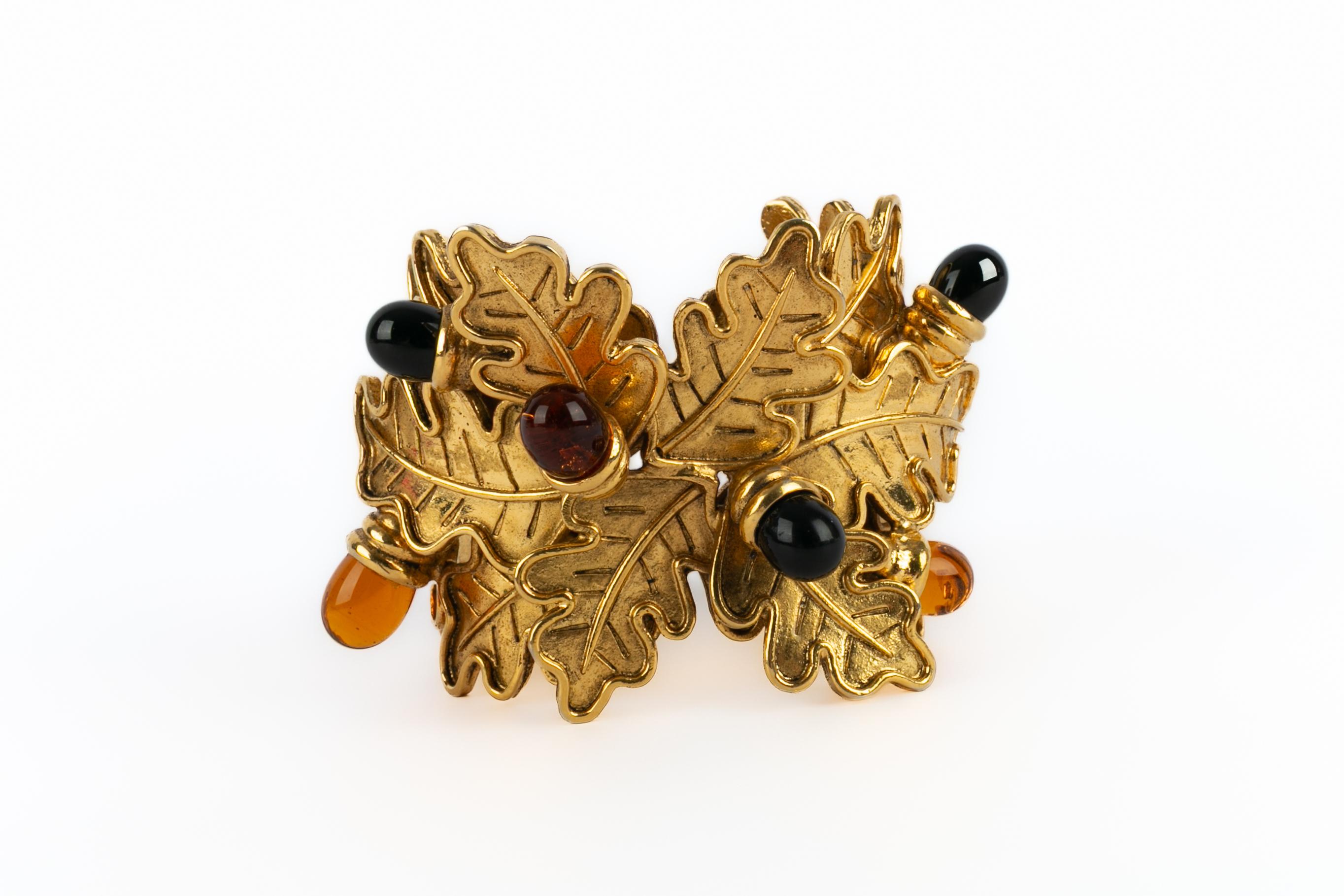 LOEWE - (Made in France) Golden metal cuff bracelet representing oak leaves and glass paste acorns. Jewelry from the late 1990s.

Condition:
Very good condition

Dimensions:
Circumference: 14 cm - Opening: 3 cm - Width: 6 cm

SKU:BRA179