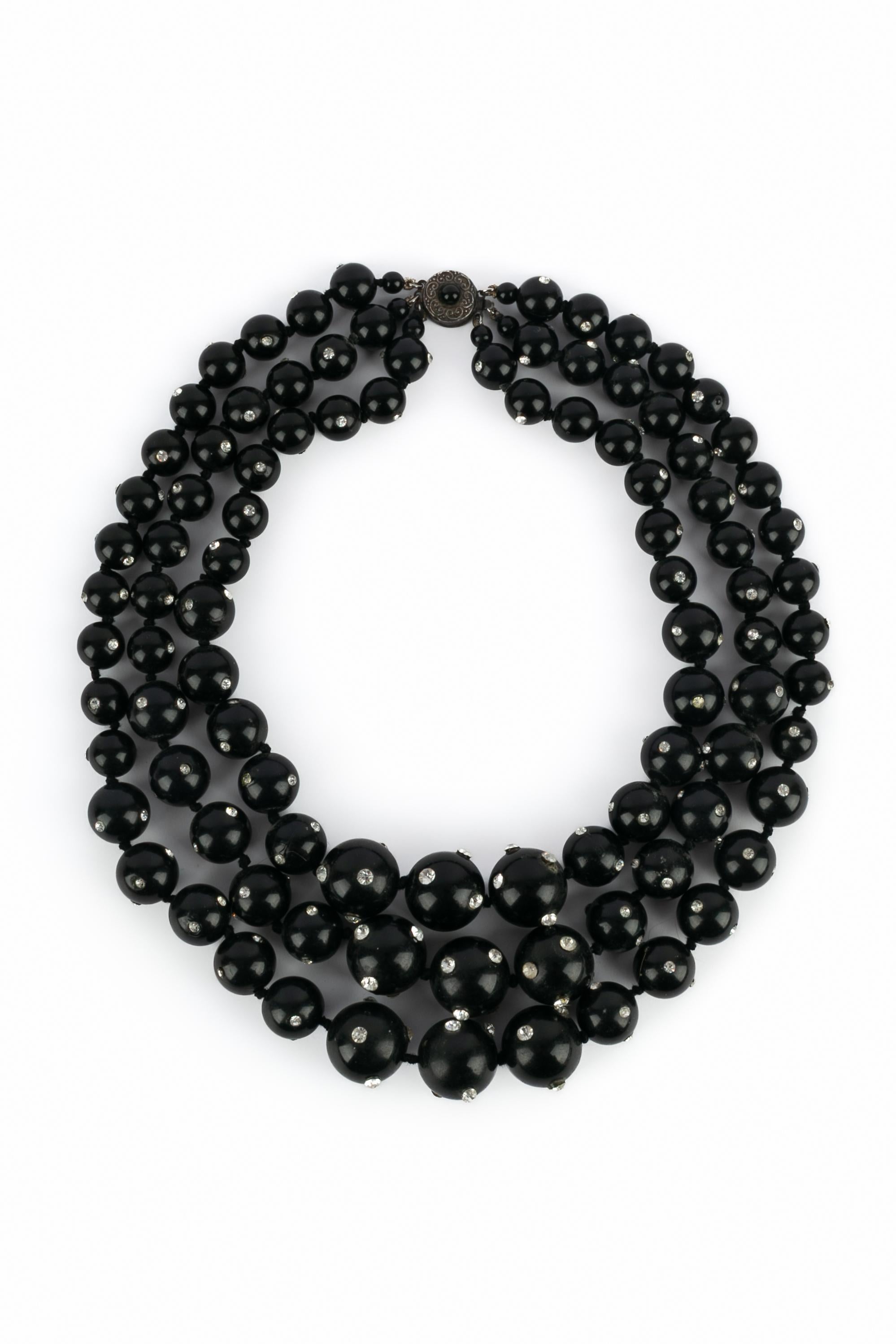 UNBEKANNT - Halskette, bestehend aus drei schwarzen Bakelitperlenreihen und Strasssteinen. Nicht signierter Schmuck aus den 1920er Jahren.

Bedingung:
Sehr guter Zustand

Abmessungen:
Länge der kürzeren Reihe: 46 cm

SKU:BC191