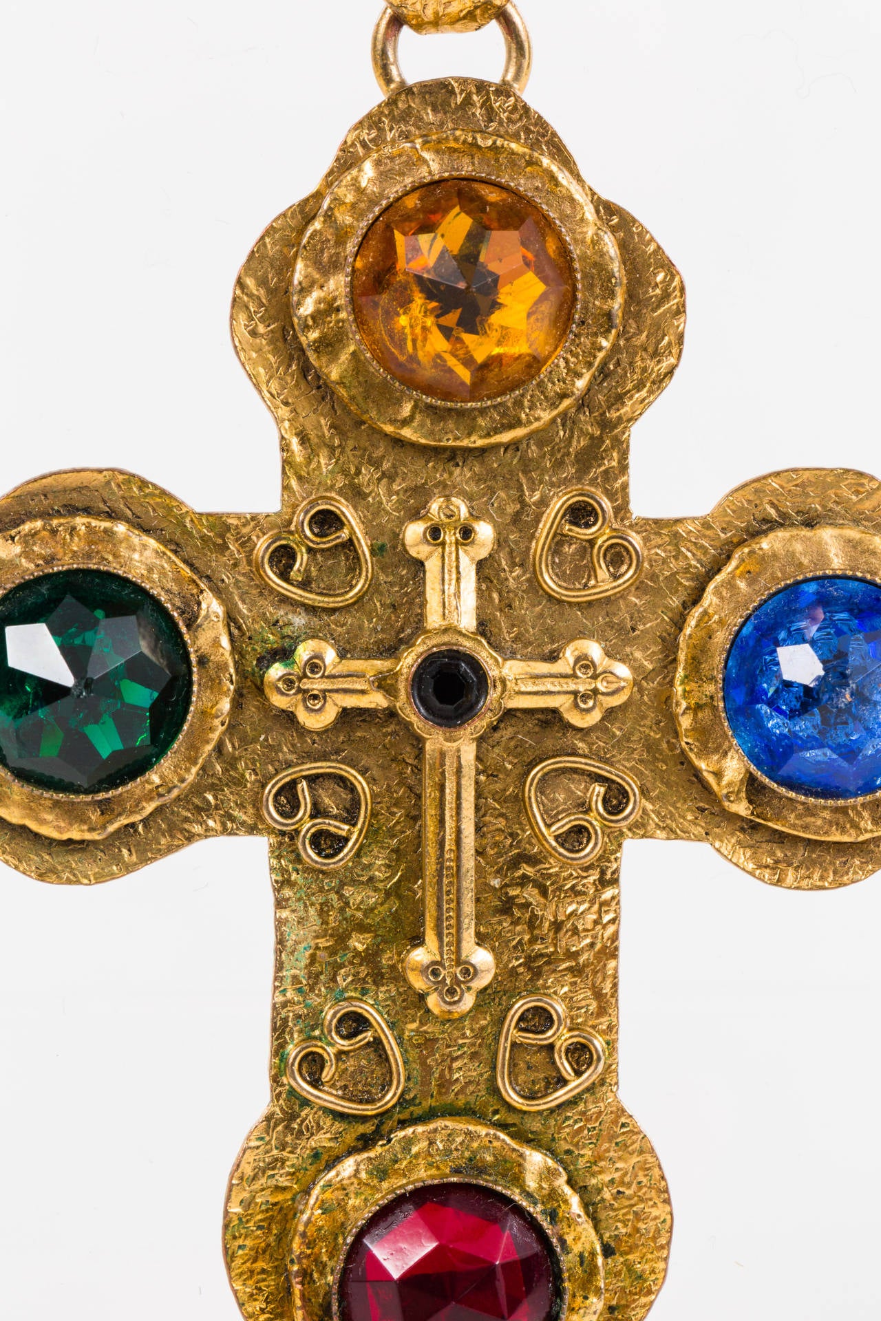 Excellent example of a piece by mid century Parisian costume jewelry designer, Henry. The designer frequently utilized themes of fantasy and Neo-Romanticism. This large cross is made of gilt metal with faceted glass faux gemstones. Pendant is
