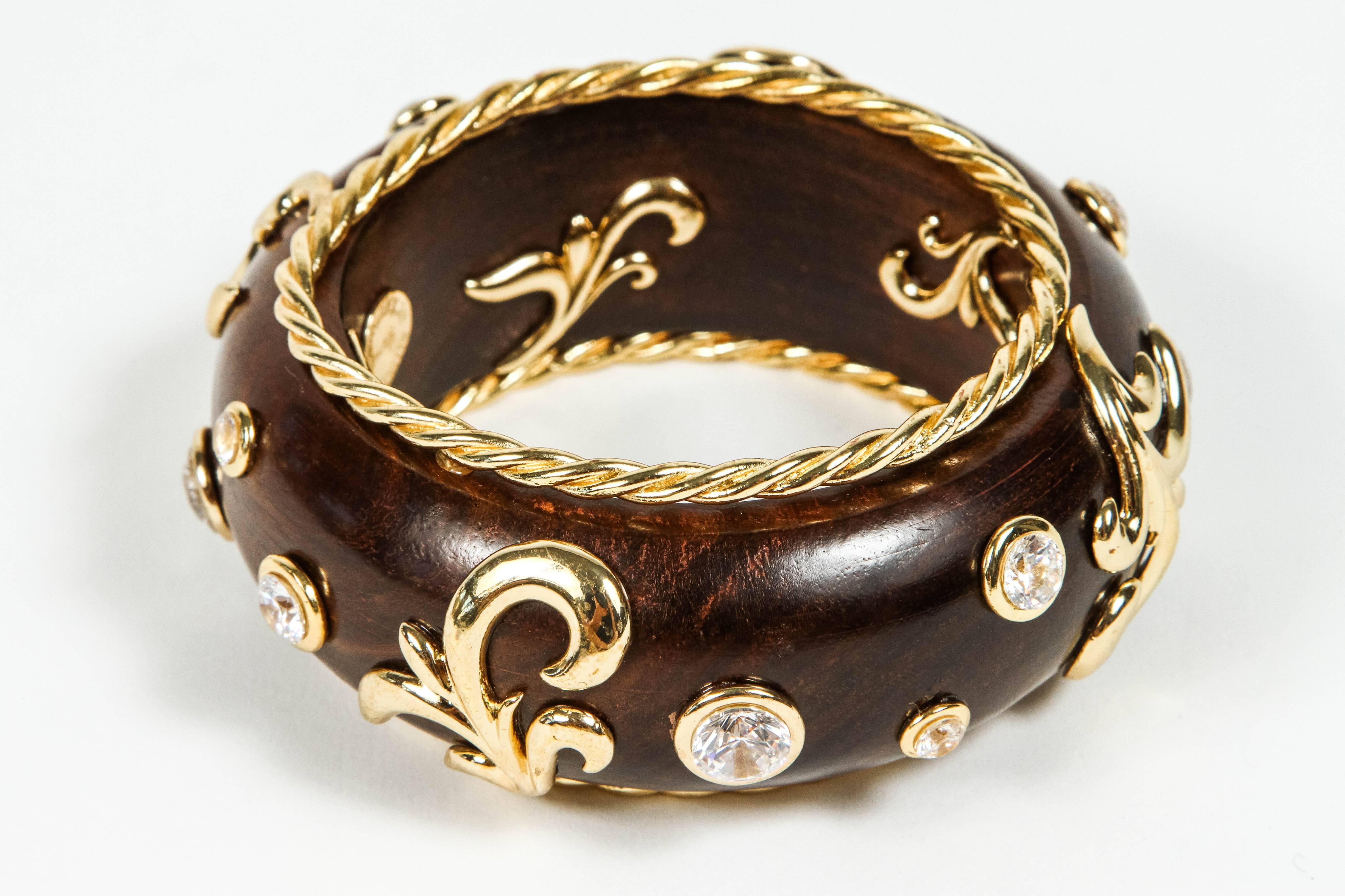 This bangle is a showstopper.  a polished wood bangle is decorated with the addition of gilt metal swirls and brilliant rhinestones bezel set into the wood.

