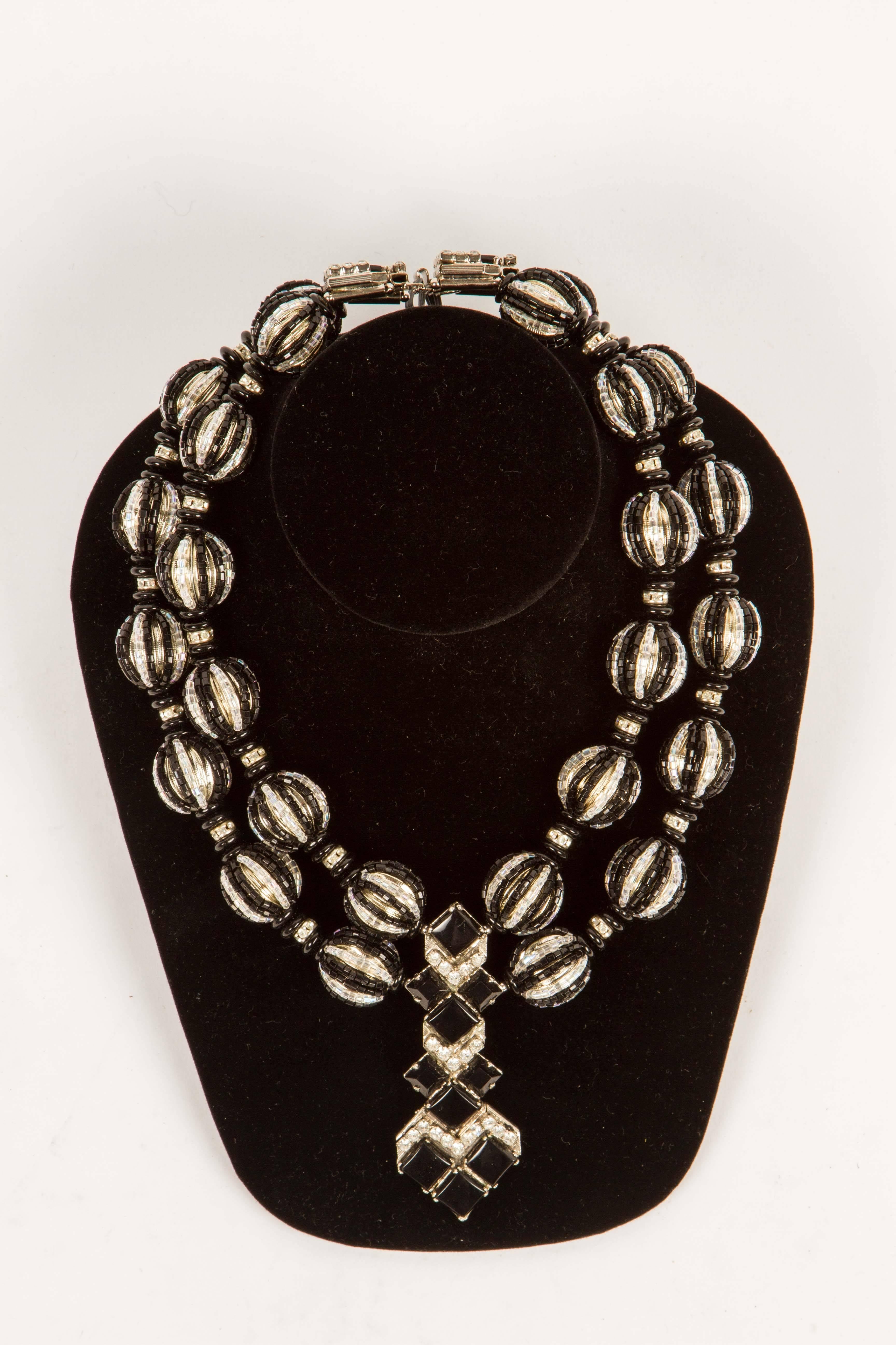A real showstopper, this Art Deco inspired necklace, a revival look popular in the 1970's, with the look of onyx and crystal set in silvered metal.  Round metal beads are covered in both black and clear crystal beads and there are rhinestones