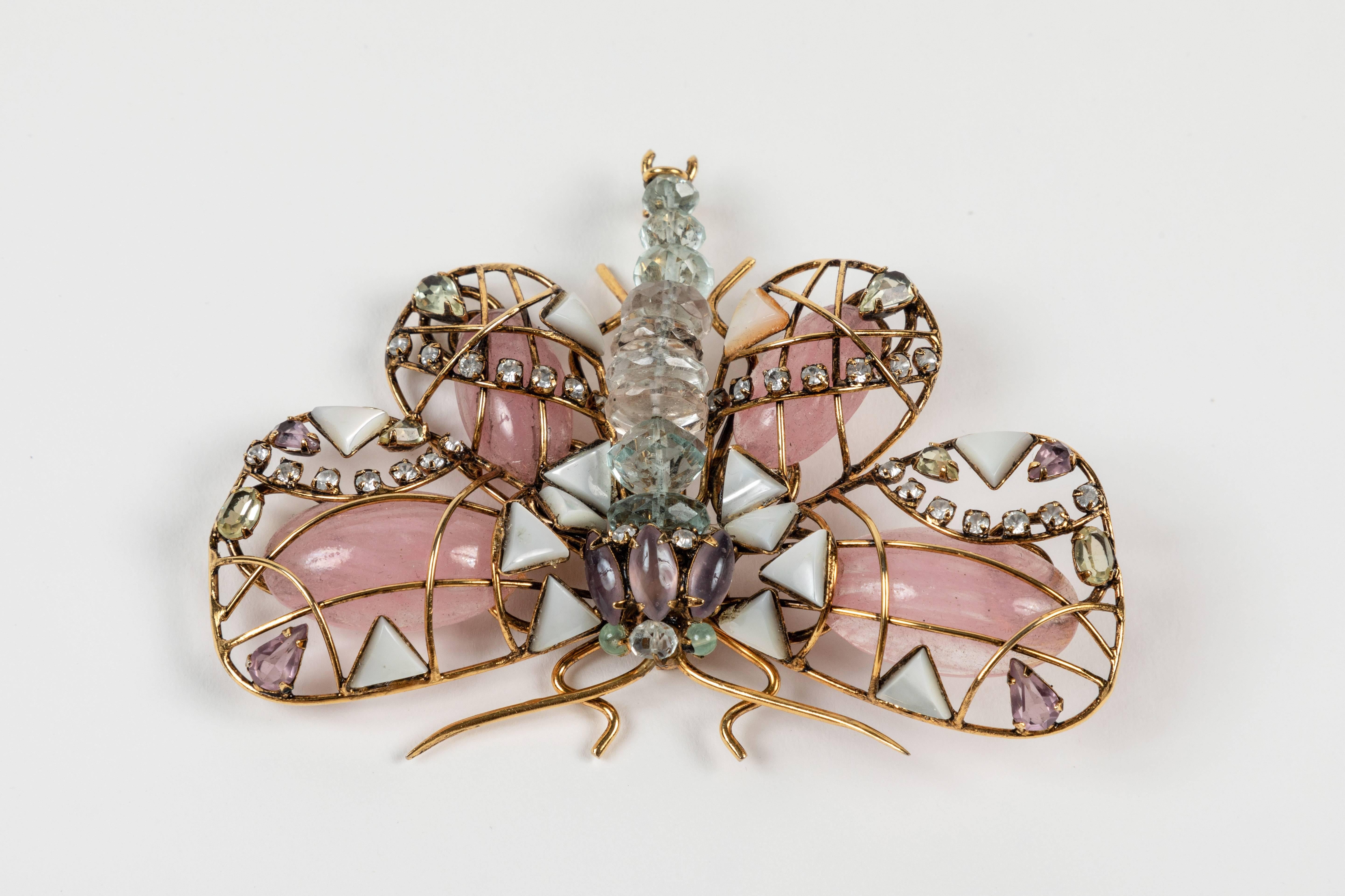 Large and impressive butterfly brooch featuring wings of Rose Quartz, Mother of pearl, and Amethyst and a body of Aquamarines.  All set in a gilt metal frame.  Signed on the reverse and including the original tag.  A real beauty!