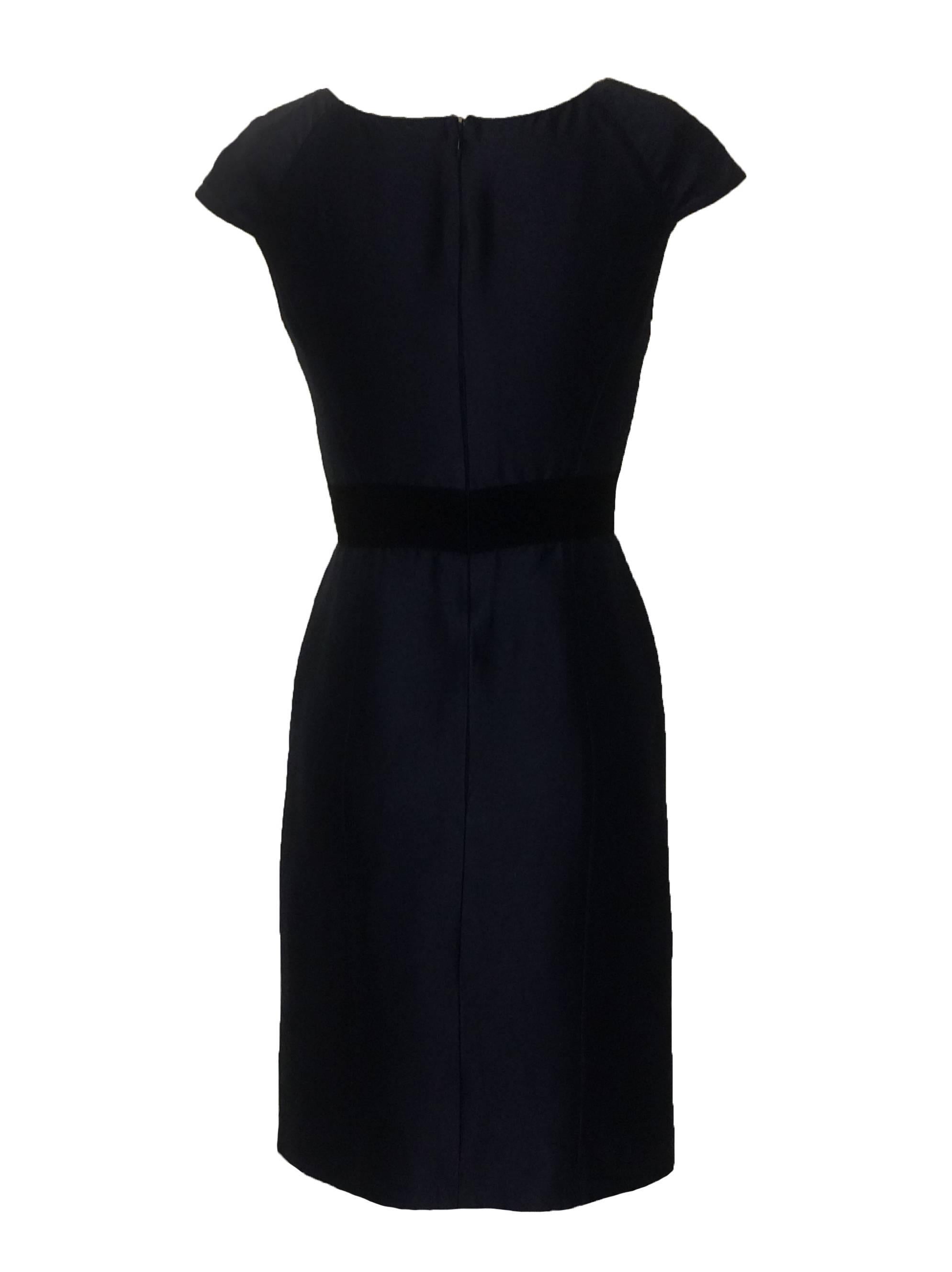 Oscar de la Renta navy pencil dress with tweed panel at front. Fringed grosgrain trim around panel and grosgrain accent at waist. Pockets hidden behind tweed at front waist. Back zip and hook and eye.

Made in Italy.

Cotton blend, fully
