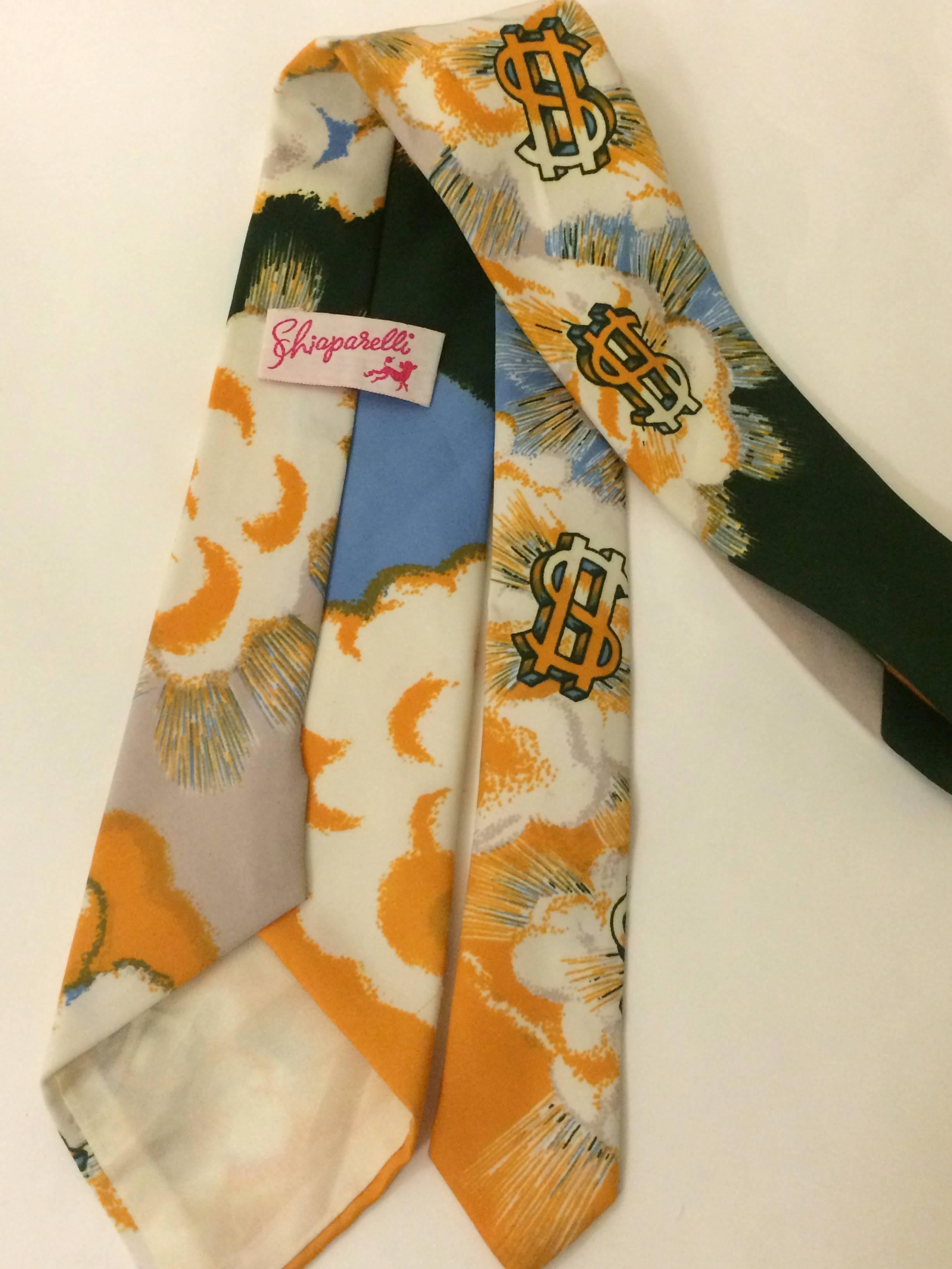 Schiaparelli vintage 70's neck tie with shining dollar signs perched on clouds, all afloat on a background of marigold, deep green, and sky blue. Certainly one of a kind! 

Total length 55