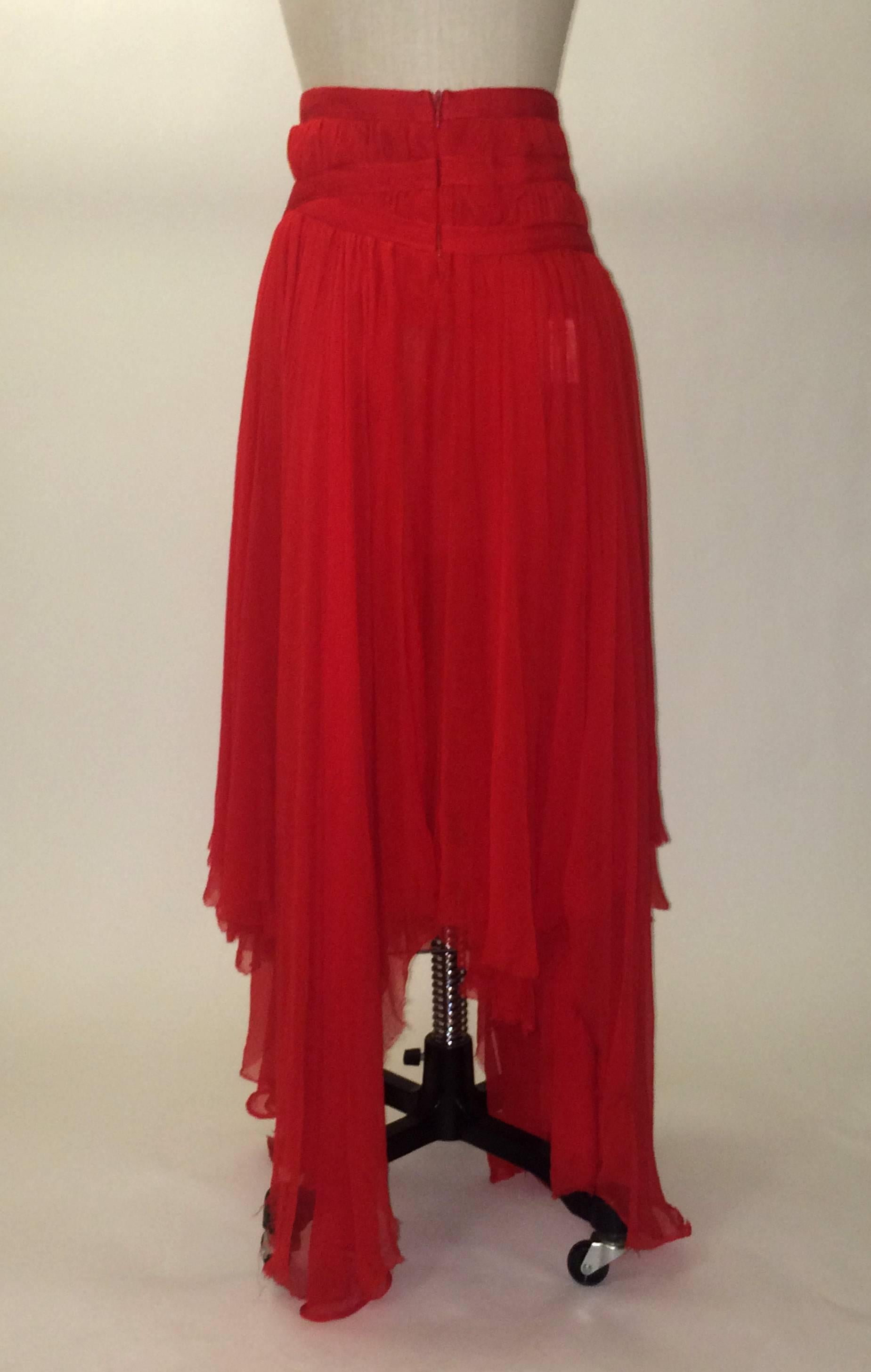 Alexander McQueen flowing red skirt with criss cross straps at hip and asymmetrical (raw edged) distressed hem. Semi sheer, top 8 inches are lined (content tag is visible through fabric, but there seem to be no issues with wearability.) Sits low on