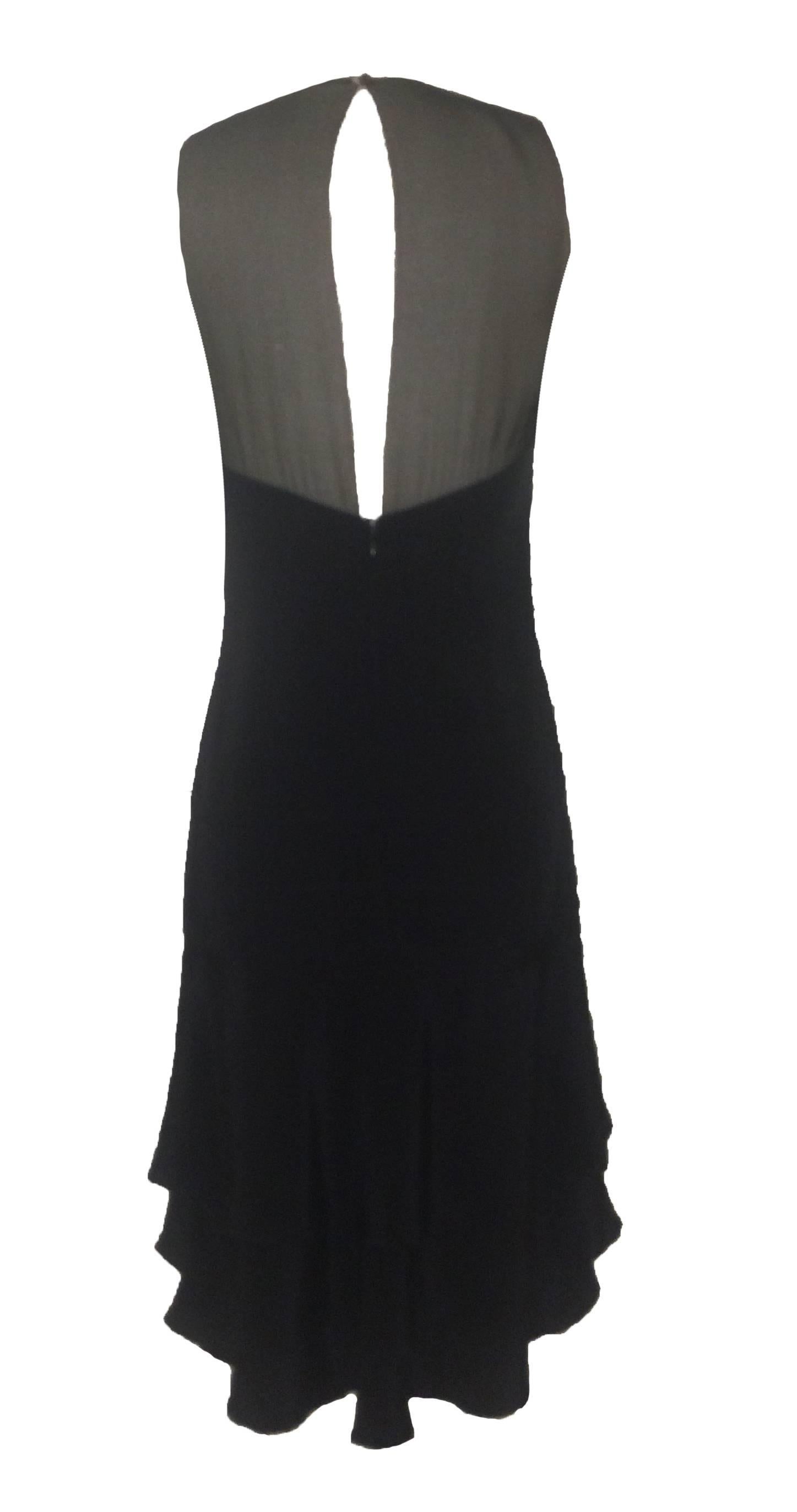 Chanel little black silk dress with sheer panels at chest and back and tiered ruffle bottom. Peekaboo keyhole slit at top back. Chanel logo plaque at hip.

Back zip, hook and eye, and button. Fully lined.

100% silk.
Made in France.

Labelled