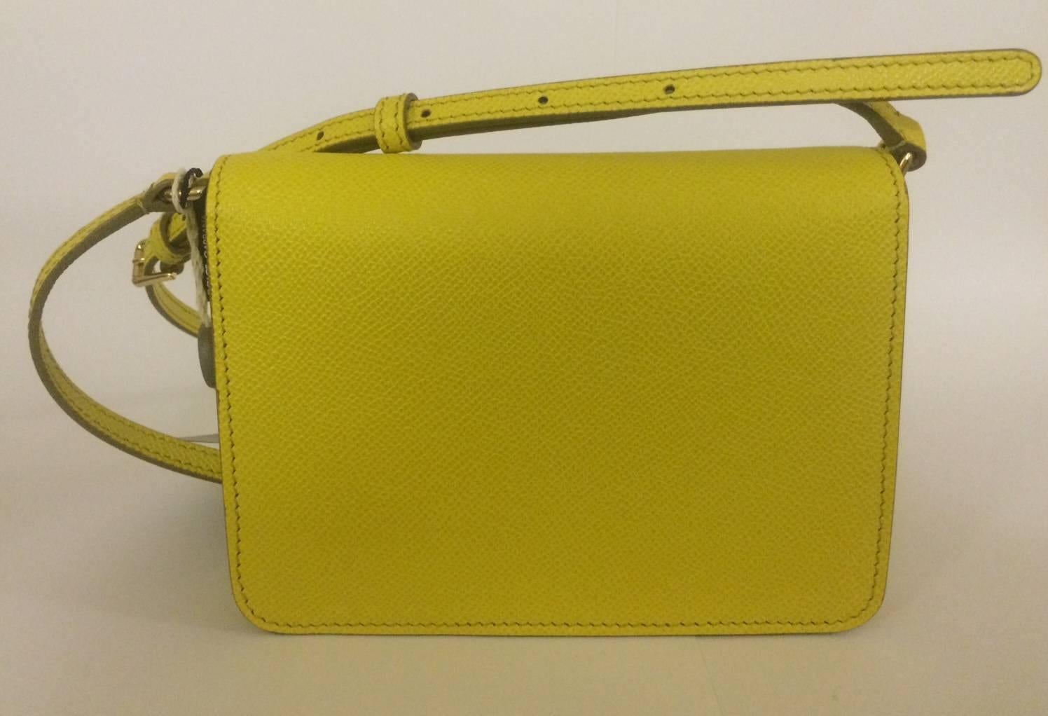 Dolce & Gabbana yellow textured leather cross body bag with front flap closure. Magnetic front snap, card slot beneath flap and at inner bag. Adjustable strap.

Signed 'Dolce & Gabbana, Milano, Italia' at front hardware.

Approximately 6