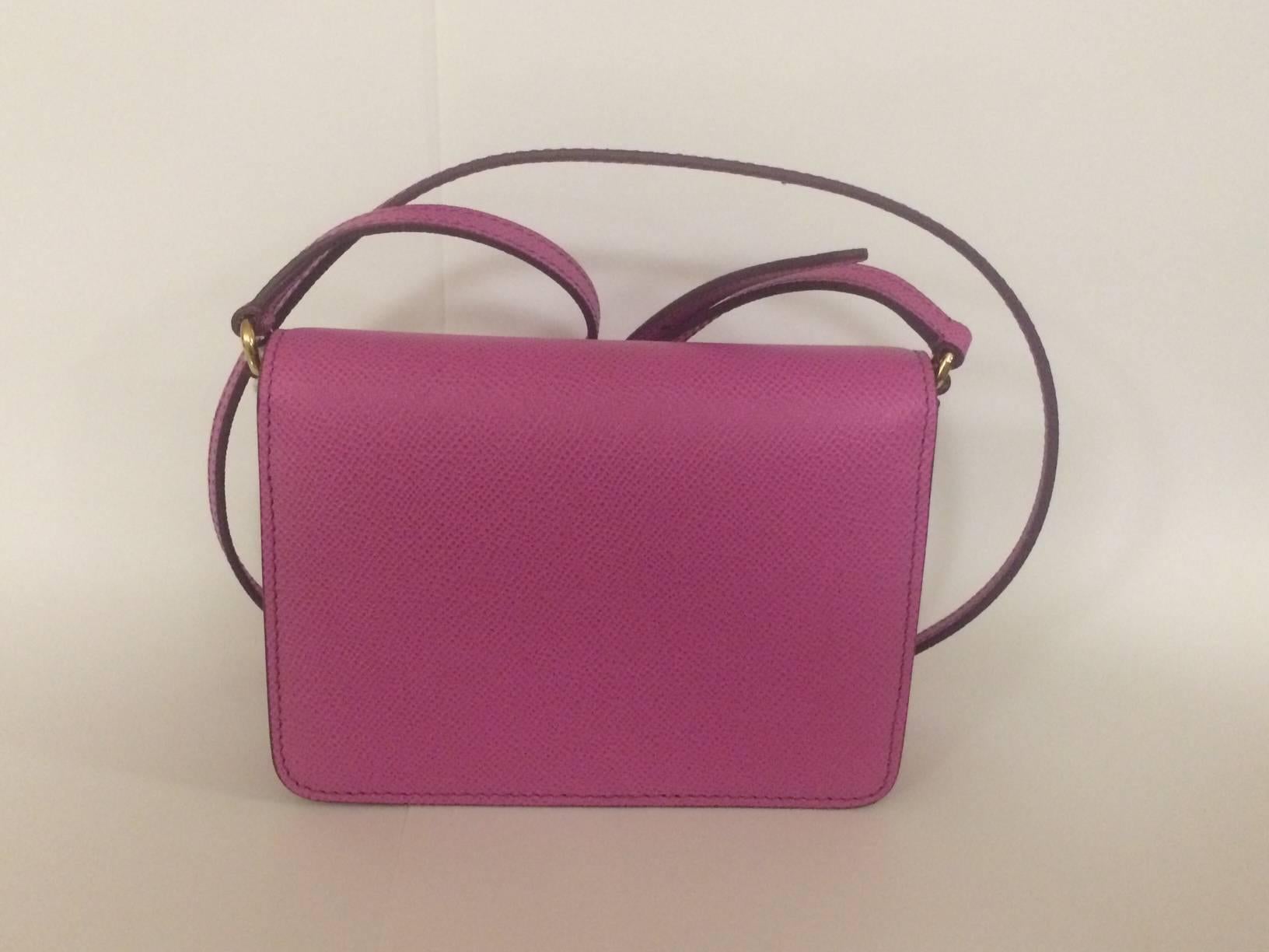 Dolce & Gabbana purple pink textured leather cross body bag with front flap closure. Magnetic front snap, card slot beneath flap and at inner bag. Adjustable strap.

Signed 'Dolce & Gabbana, Milano, Italia' at front