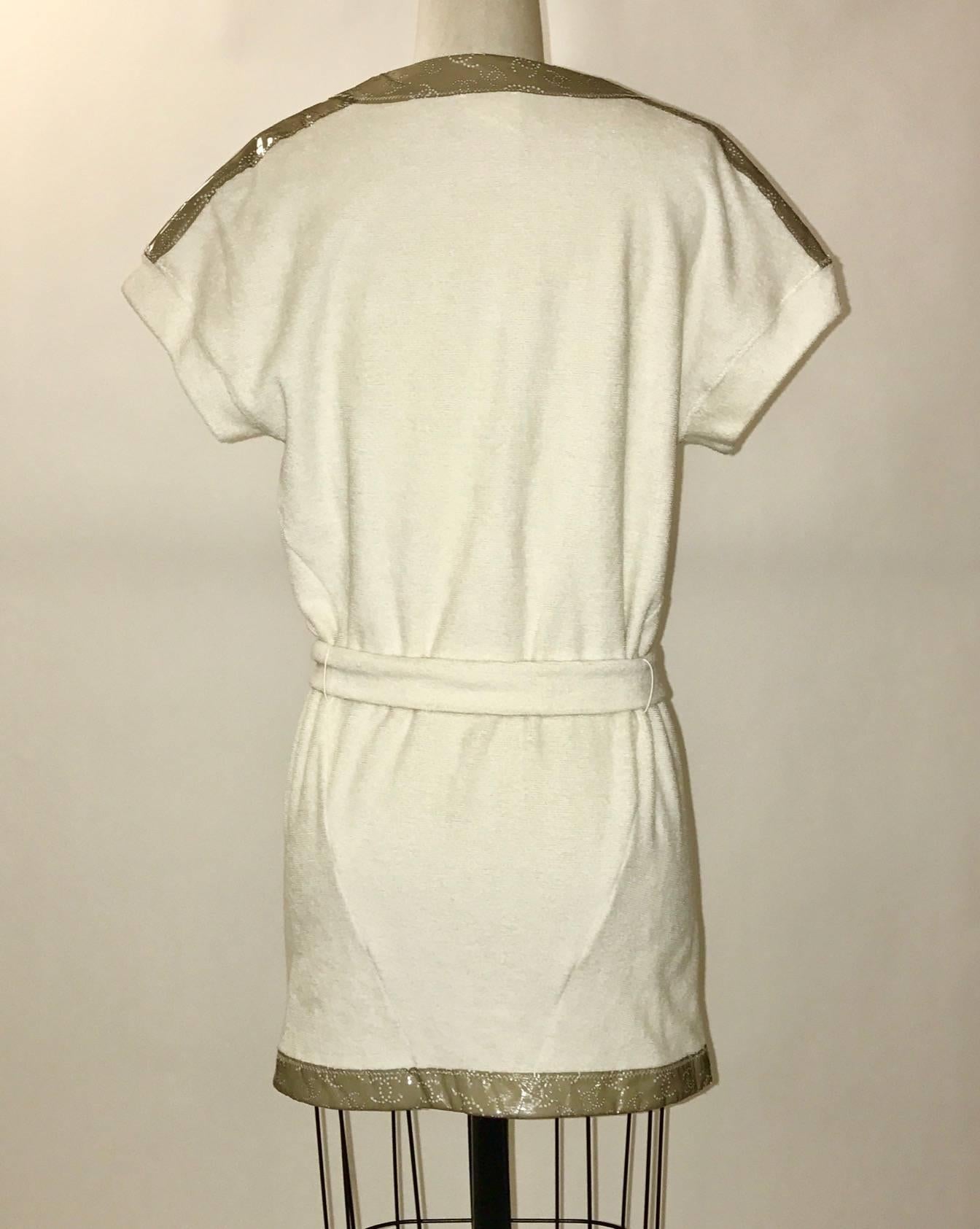 Chanel 09C short cream terry cloth robe with taupe-grey trim featuring perforated interlocking C logos. Short sleeves, removable belt. Perfect over a swimming suit for the beach or pool, or great for loungewear.

100% cotton.

Size FR 34, best
