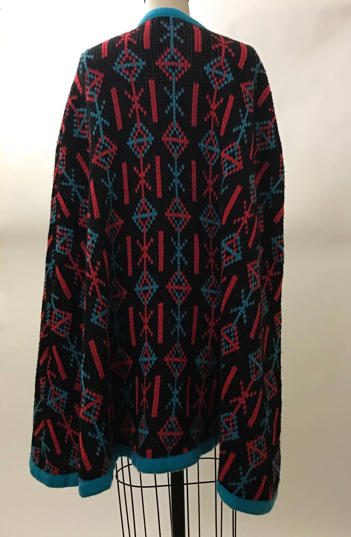 1970's Giorgio Sant'Angelo Knits beautifully double knitted cape in black, red, and blue geometric print. Ties at neck.

100% virgin Orlon (Dupont acrylic fiber.)

Made in USA. 

One size.
Approximately 34