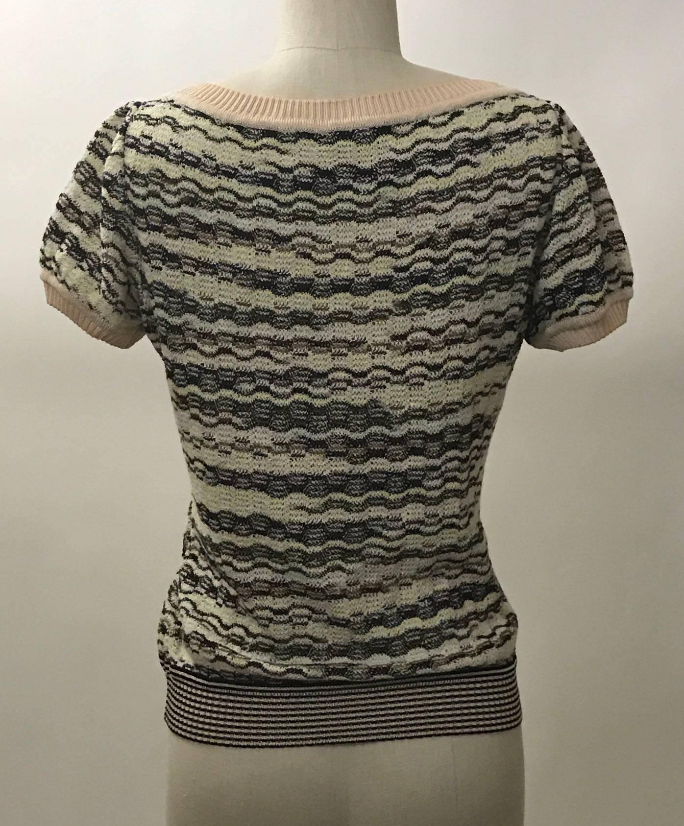 Missoni fruit sweater from the 2005 'Collectable' collection. Embroidered and beaded fruits adorn the front of this classic Missoni pattern knit sweater. Short sleeves, deep v neck, rib knit trim at neck and sleeves.

Marked 88/500.

60% rayon,